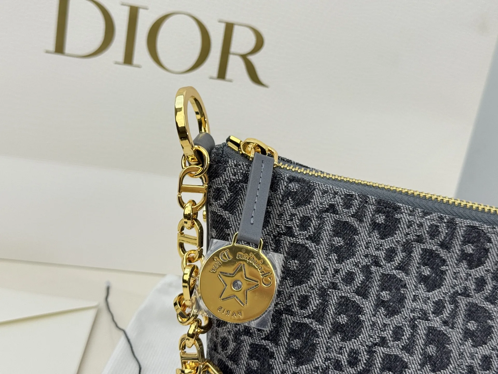 （折叠盒⚠️）p195 迪奥Dior 牛仔链条饭盒（自带延长带） 这款 Diorstar Hobo 链条手袋造型时尚，设计实用。采用蓝色 Denim Dior Oblique 提花面料精心制作，以不规则的石洗效果焕新演绎 Dior 的经典图案，彰显现代魅力，柔软版型搭配宽敞隔层。拉链开合，搭配镌刻以 Christian Dior Paris 标志和 Dior 经典星星标识的圆形饰牌，侧面饰以精致的 CD 铆钉，更显格调。内部带有绒面牛皮革里料，配有卡槽。搭配可调节的 CD 链条肩带，并带有皮革带，提升肩背时的舒适度。 size：22.16cm