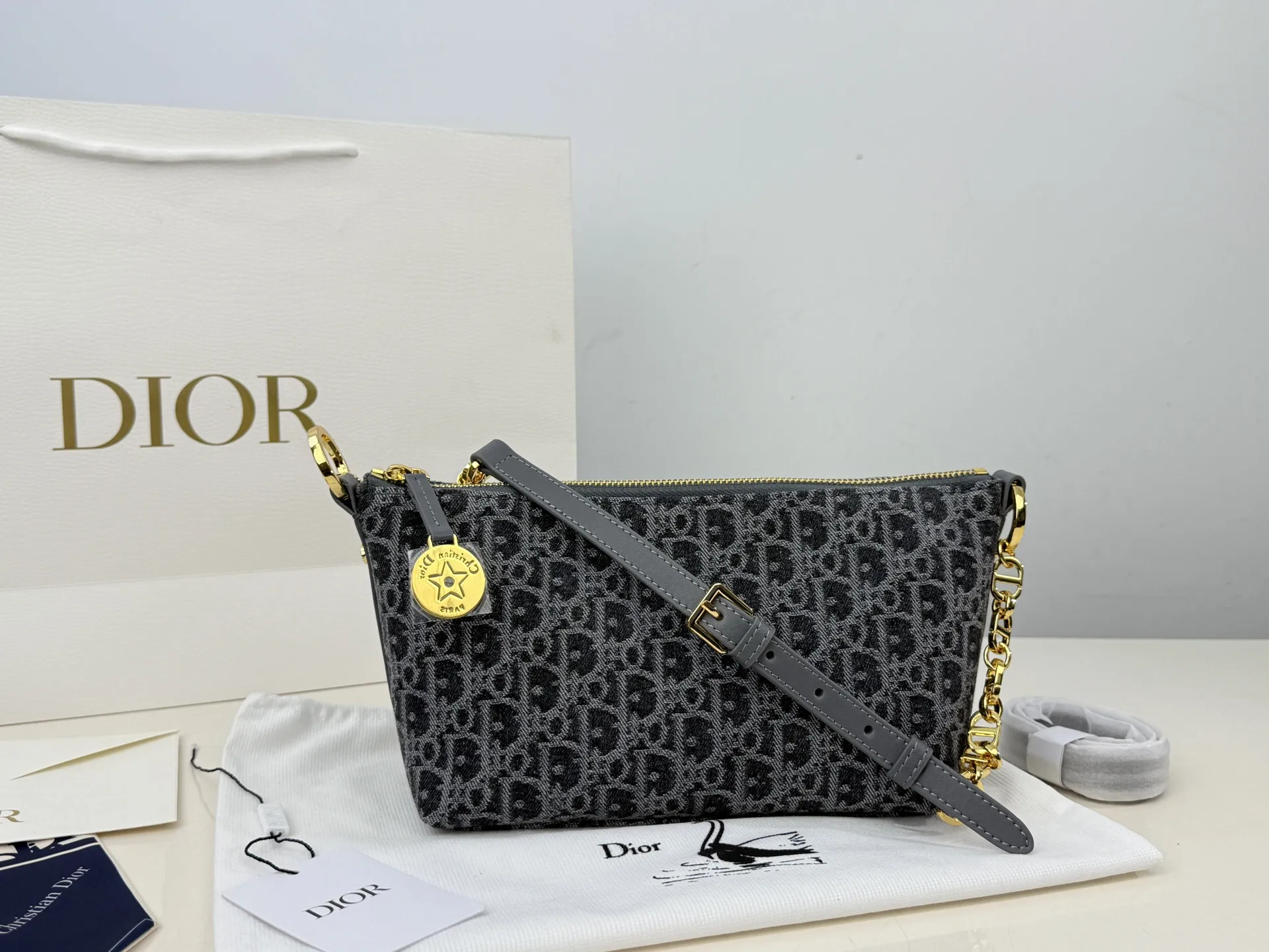 （折叠盒⚠️）p195 迪奥Dior 牛仔链条饭盒（自带延长带） 这款 Diorstar Hobo 链条手袋造型时尚，设计实用。采用蓝色 Denim Dior Oblique 提花面料精心制作，以不规则的石洗效果焕新演绎 Dior 的经典图案，彰显现代魅力，柔软版型搭配宽敞隔层。拉链开合，搭配镌刻以 Christian Dior Paris 标志和 Dior 经典星星标识的圆形饰牌，侧面饰以精致的 CD 铆钉，更显格调。内部带有绒面牛皮革里料，配有卡槽。搭配可调节的 CD 链条肩带，并带有皮革带，提升肩背时的舒适度。 size：22.16cm