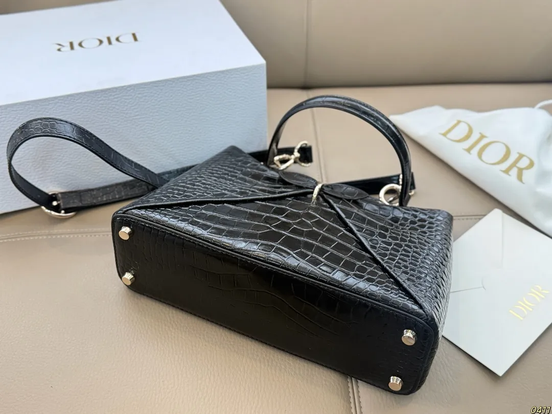&yen;300折叠盒 迪奥 Dior 2026春夏蝴蝶结手提包 质感细腻又耐用。正面立体蝴蝶结设计，优雅又俏皮，梯形包型容量适中，通勤休闲都很OK。顶部硬质手柄＋可调节肩带，手提斜挎随心切换。 整体简约精致，法式浪漫氛围感拉满，是2026春夏系列超亮眼单品！尺寸28*19.5