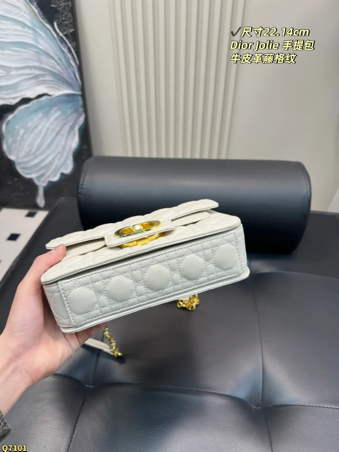 💰155配折叠盒 尺寸22.14cm 迪奥Dior Jolie 手提包是2025春夏成衣系列新品,兼具优雅气质与实用功能。采用黑色牛皮革精心制作,饰以藤格纹缉面线,双重翻盖饰以 CD 标志提升格调,点缀以白色树脂珠饰,三隔层和拉链口袋可收纳各种日常用品,可与日常或晚装造型搭配。小号款式,搭配可拆卸手柄与可拆卸链条肩带,肩带由皮革带和 CD 标志链环组成,饰以白色树脂珠饰,可舒适手提、肩背或斜挎。