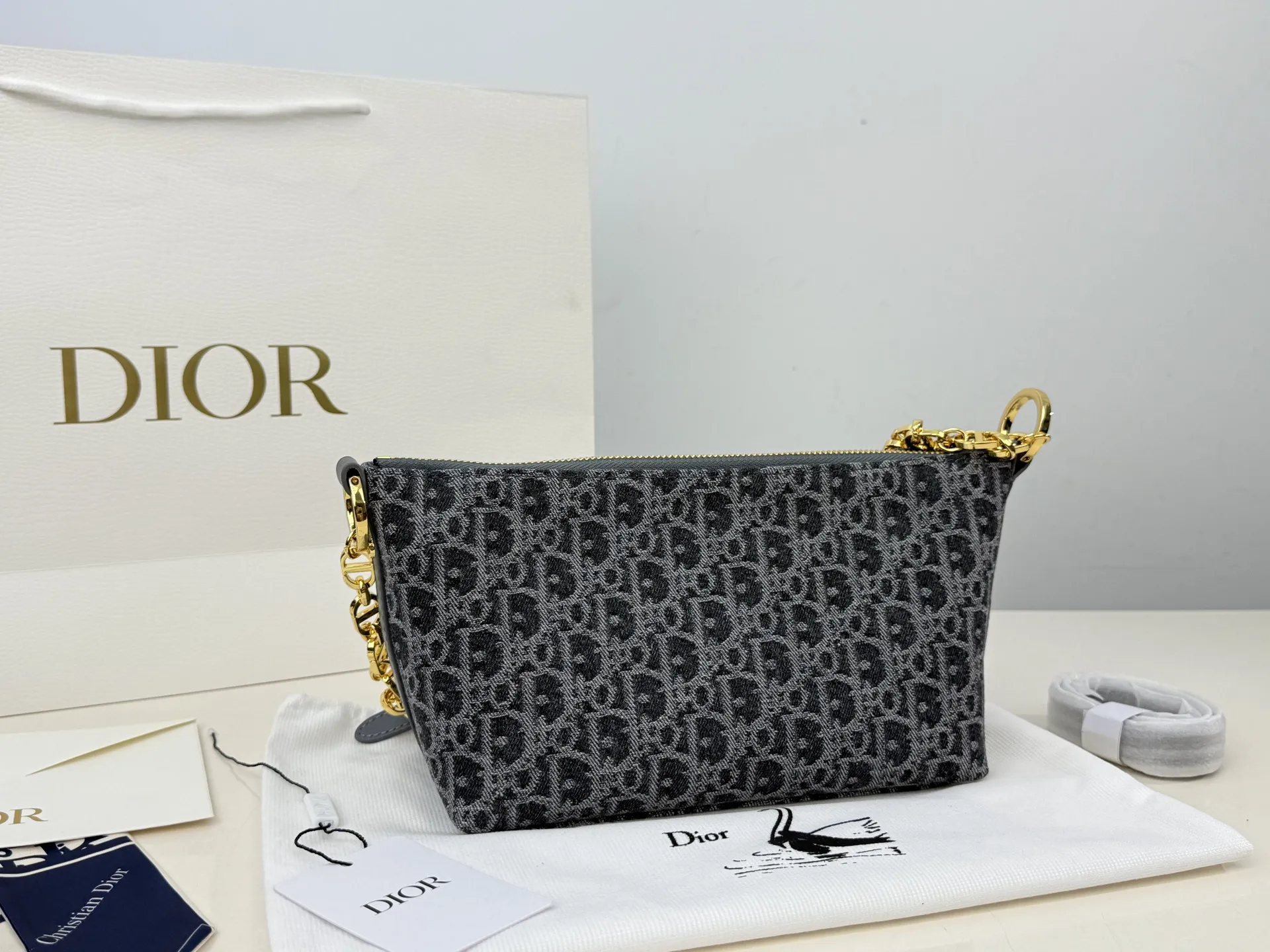 (折叠盒⚠️)p195 迪奥Dior 牛仔链条饭盒(自带延长带) 这款 Diorstar Hobo 链条手袋造型时尚,设计实用。采用蓝色 Denim Dior Oblique 提花面料精心制作,以不规则的石洗效果焕新演绎 Dior 的经典图案,彰显现代魅力,柔软版型搭配宽敞隔层。拉链开合,搭配镌刻以 Christian Dior Paris 标志和 Dior 经典星星标识的圆形饰牌,侧面饰以精致的 CD 铆钉,更显格调。内部带有绒面牛皮革里料,配有卡槽。搭配可调节的 CD 链条肩带,并带有皮革带,提升肩背时的舒适度。 size:22.16cm