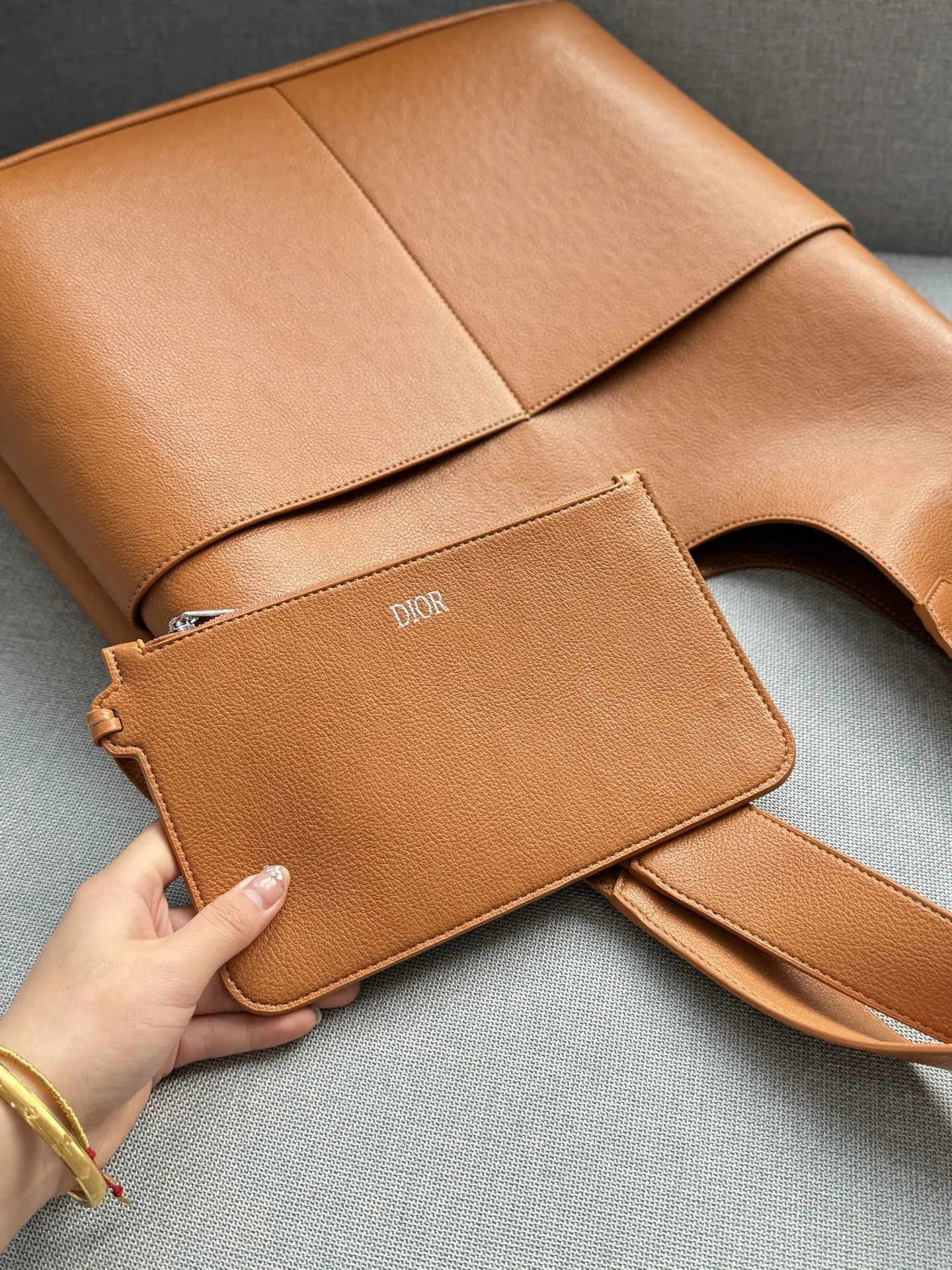 💰205 size：41&times;33 DIOR迪奥 Priv&eacute; 腋下包 托特包Tote包购物袋 手提包 细腻高级的小牛皮材质 每一次触碰都能感受到这款包的价值 低调的设计，高级男包该有的私密奢华 足够大的容量，型男通勤绝配 配了同色的拉链手袋存放私密物件 内侧是若隐若现的DIOR老花压纹，彰显质感