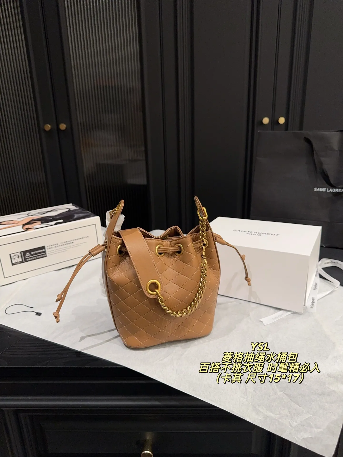 P180全套包装⚠️尺寸15*17 圣罗兰 YSL 菱格抽绳水桶包 经典黑色小牛皮＋金色链条，优雅又高级。抽绳开合，容量大，通勤出街都超实用！菱格纹缝线细节满分，链条肩带可调节，单肩斜挎都OK，百搭不挑衣服~轻奢时尚感拉满，是圣罗兰热门款，时髦精必入！