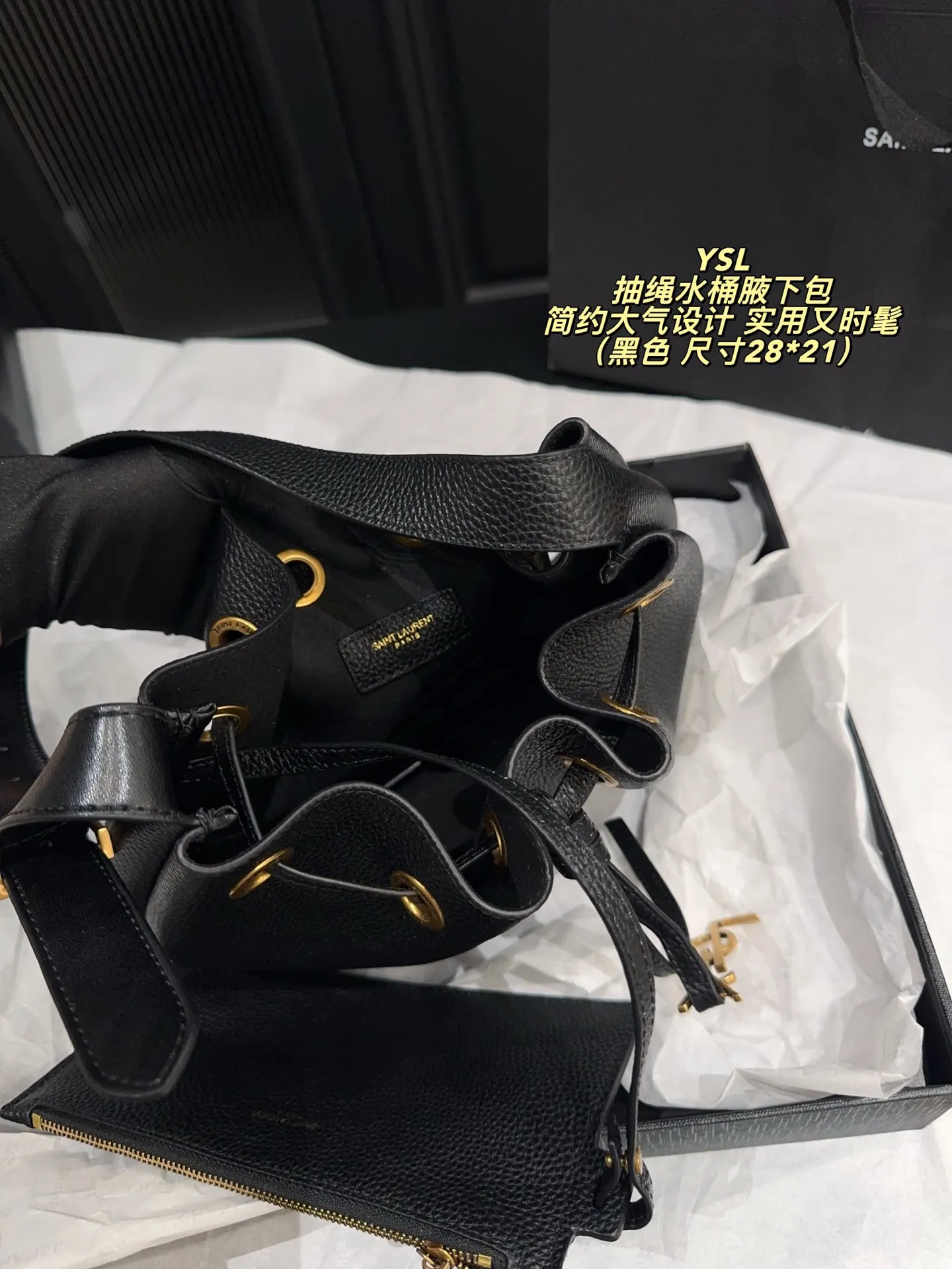 P200配折叠盒⚠️尺寸28*21 圣罗兰 YSL 抽绳水桶腋下包 黑色荔枝纹牛皮,质感细腻耐用,金属抽绳十YSL标志超有辨识度。尺寸适中,通勤休闲都能用,手提斜挎随心切换,内部空问合理,日常物品轻松收纳。简约大气设计,百搭不挑风格,秋冬深色系穿搭必备,实用又时髦!