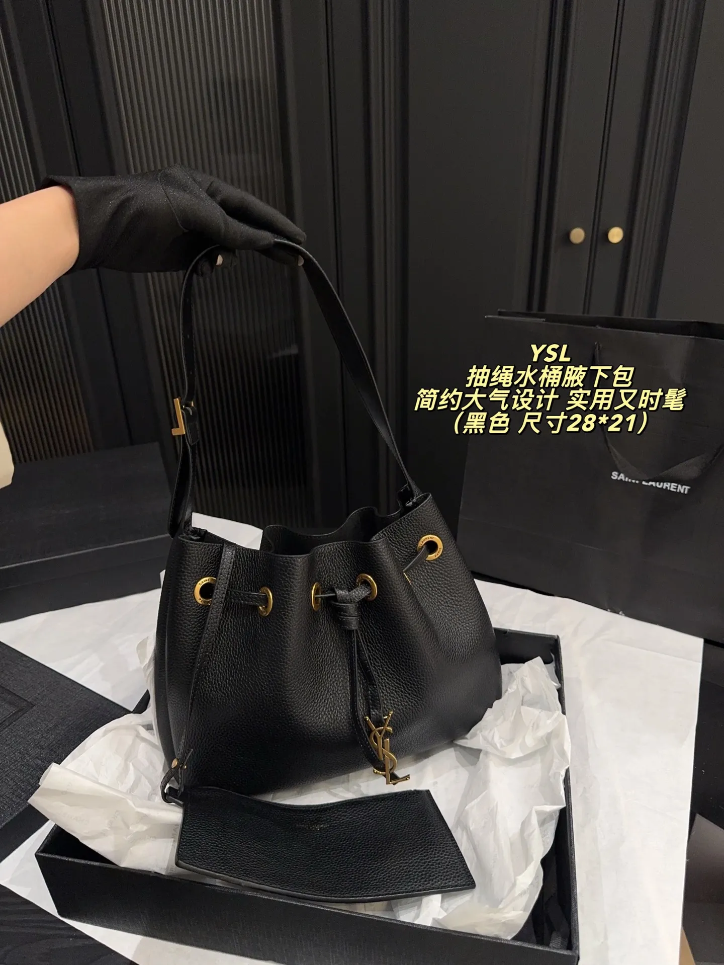 P200配折叠盒⚠️尺寸28*21 圣罗兰 YSL 抽绳水桶腋下包 黑色荔枝纹牛皮，质感细腻耐用，金属抽绳十YSL标志超有辨识度。尺寸适中，通勤休闲都能用，手提斜挎随心切换，内部空问合理，日常物品轻松收纳。简约大气设计，百搭不挑风格，秋冬深色系穿搭必备，实用又时髦！