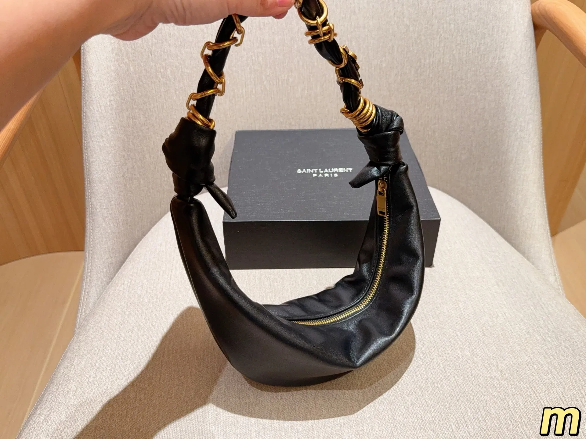 💰135 圣罗兰YSL AMALIA腋下包 柔软慵懒随性&ldquo;牛角包&rdquo;造型，超有法式氛围感！肩带是金色YSL字母链条交织，辦识度满分-。拉链开合，内部空问能装手机、钱包等日常小物，手提或腋下背都很时髦，轻松打造松弛感穿搭~ 尺寸39&times;13 礼盒包装🎁