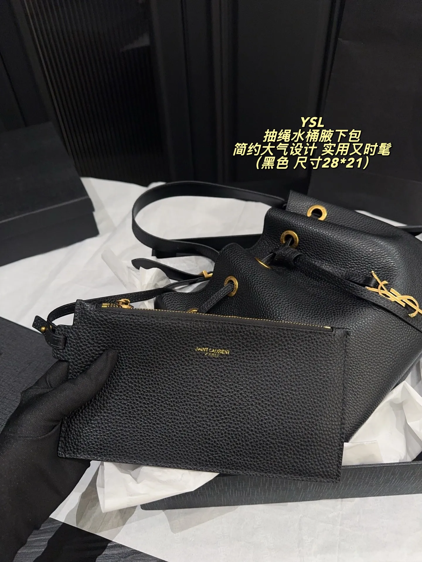 P200配折叠盒⚠️尺寸28*21 圣罗兰 YSL 抽绳水桶腋下包 黑色荔枝纹牛皮,质感细腻耐用,金属抽绳十YSL标志超有辨识度。尺寸适中,通勤休闲都能用,手提斜挎随心切换,内部空问合理,日常物品轻松收纳。简约大气设计,百搭不挑风格,秋冬深色系穿搭必备,实用又时髦!