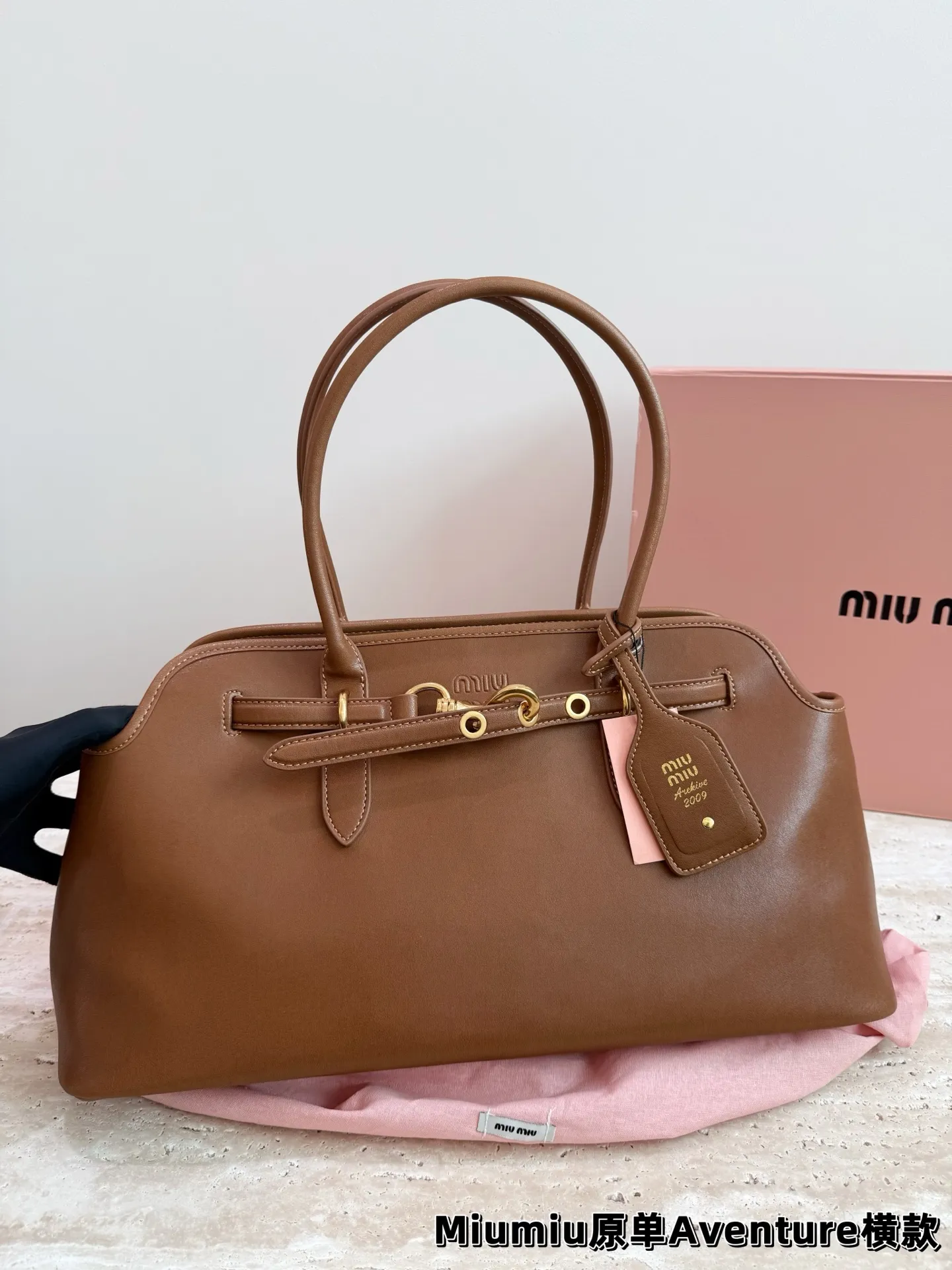 P240 miumiu复古Aventure系列贝壳包 Aventure系列贝壳手提/斜挎包.上线啦! 24ss最流行款式,做旧褪色感的皮革颜色与质地,配上金属皮带搭扣高级又复古,采用小牛皮制作的包身设计精致,方正复古的造型 手提腋下斜挎包随意切换! 优雅通勤超好穿快快加入miu女孩吧! 尺寸:超大号46*23cm复古包#牛皮包包