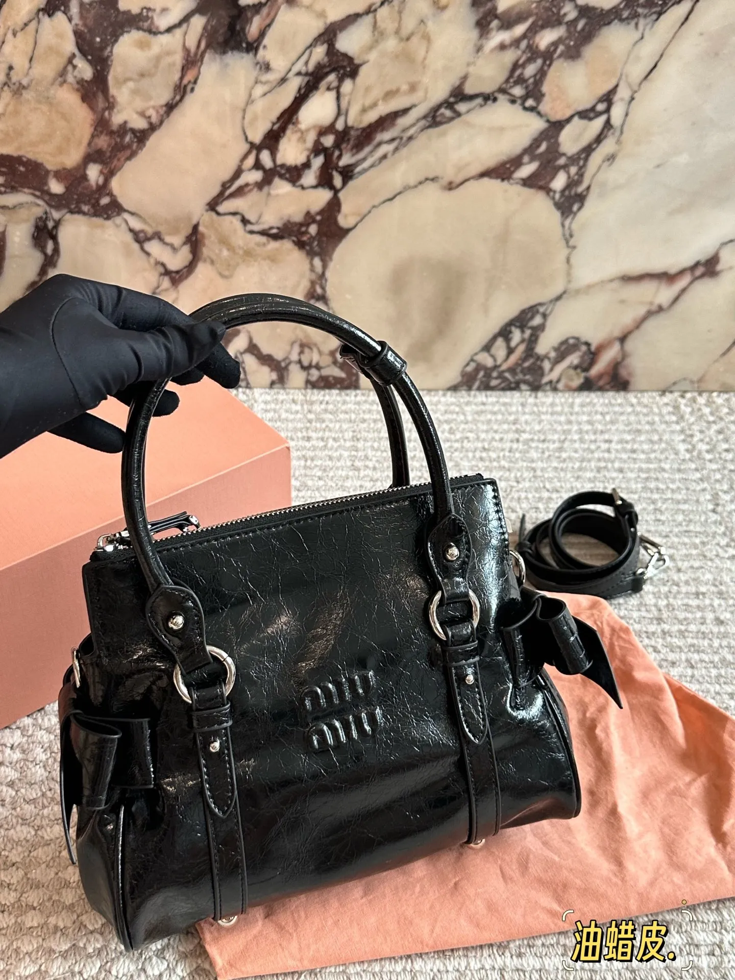 p280 MiuMiu蝴蝶结机车包​​ ✨MiuMiu蝴蝶结机车包，油蜡小牛皮材质，细腻光泽+复古褶皱感，摩卡棕配银色五金，甜酷复古风满分！两侧蝴蝶结超少女，手提斜挎都OK，日常通勤、休闲出街都能轻松驾驭👜。容量适中，手机、化妆品都能装，实用又时髦，是MiuMiu经典复刻款，复古与现代感兼具，超适合喜欢个性风格的姐妹们！💖25cm配盒子