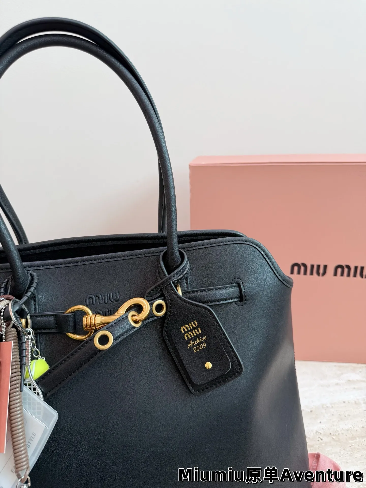 P250 MiuMiu Aventure托特包 👜MiuMiu Aventure托特包,选用橡木色小牛皮,质地柔软细腻,金属皮带搭扣超有复古感✨。尺寸约40×31×13cm,容量大,通勤日常都OK!内部斜纹帆布衬里,实用又时髦。焦糖棕色超适合秋冬,搭配风衣针织衫氛围感拉满🍂。自重轻,手提肩背都方便,是功能与设计感兼具的通勤包!配盒子