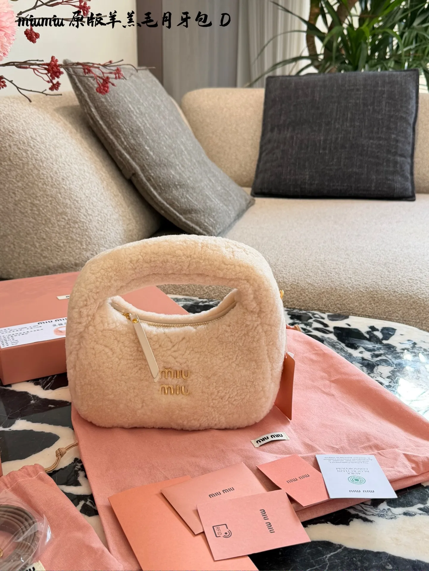 p255 Miu Miu羊羔毛Mini Wander手提包 &这款Miu Miu羊羔毛Mini Wander手提包，采用柔软羊 羔毛，触感超温暖,秋冬必备!奶茶色包身+金色L ogo刺绣，精致又有辨识度十。尺寸小巧，手提or肩背都OK,配有链条和肩带，百搭各种穿搭风格。内部空间刚好，手机、钥匙轻松收纳，实用又时髦。23cm配盒子