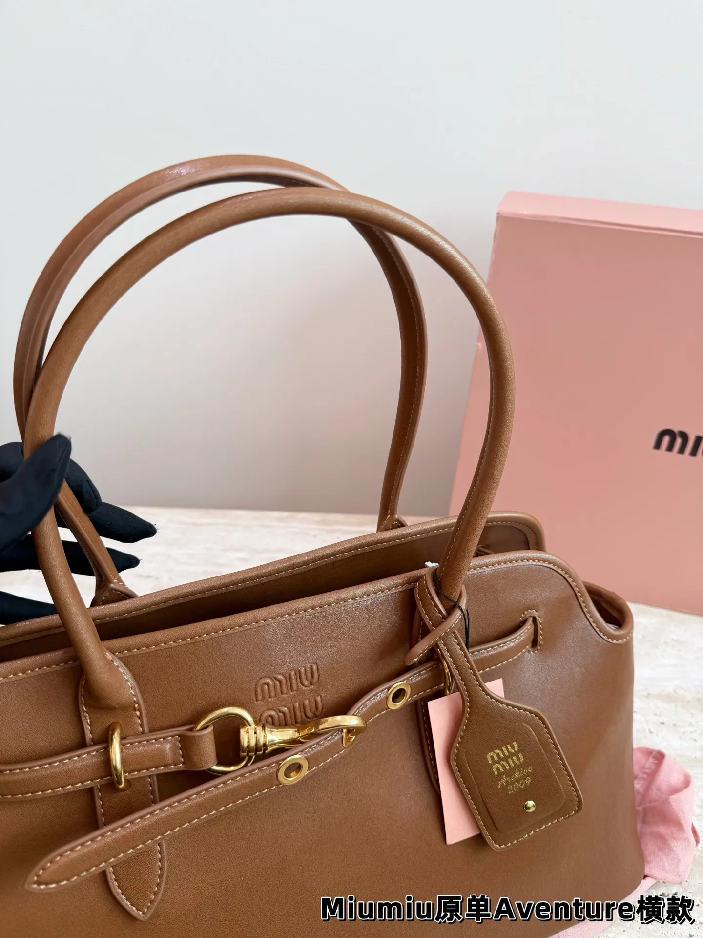 P240 miumiu复古Aventure系列贝壳包 Aventure系列贝壳手提/斜挎包.上线啦! 24ss最流行款式,做旧褪色感的皮革颜色与质地,配上金属皮带搭扣高级又复古,采用小牛皮制作的包身设计精致,方正复古的造型 手提腋下斜挎包随意切换! 优雅通勤超好穿快快加入miu女孩吧! 尺寸:超大号46*23cm复古包#牛皮包包