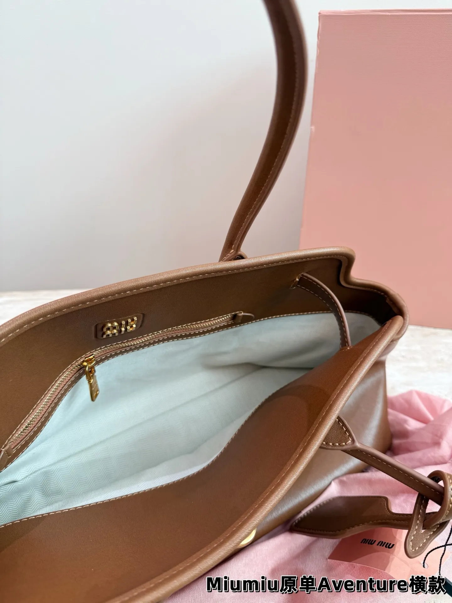 P240 miumiu复古Aventure系列贝壳包 Aventure系列贝壳手提/斜挎包.上线啦! 24ss最流行款式，做旧褪色感的皮革颜色与质地，配上金属皮带搭扣高级又复古，采用小牛皮制作的包身设计精致，方正复古的造型 手提腋下斜挎包随意切换! 优雅通勤超好穿快快加入miu女孩吧! 尺寸:超大号46*23cm复古包#牛皮包包