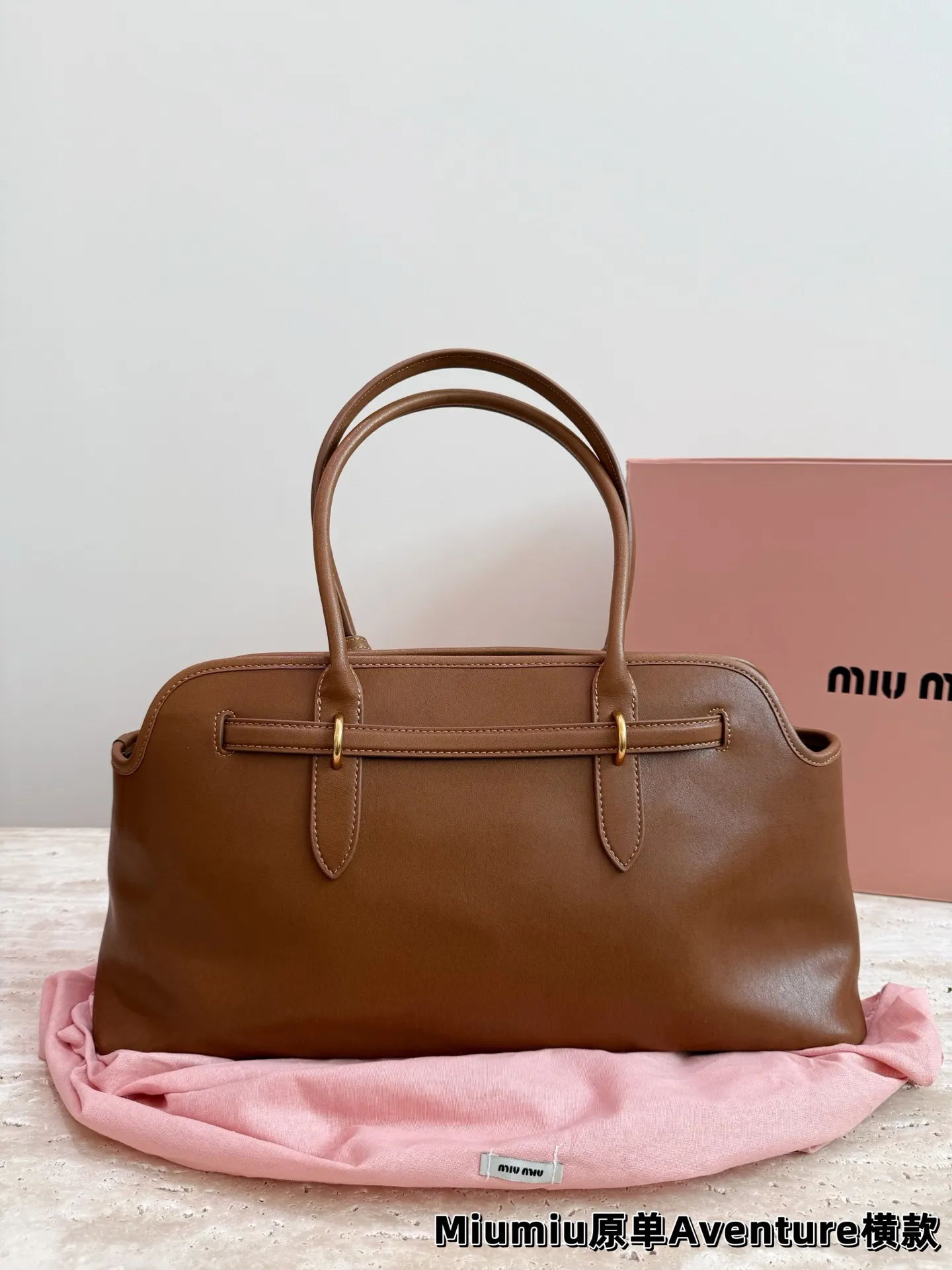 P240 miumiu复古Aventure系列贝壳包 Aventure系列贝壳手提/斜挎包.上线啦! 24ss最流行款式，做旧褪色感的皮革颜色与质地，配上金属皮带搭扣高级又复古，采用小牛皮制作的包身设计精致，方正复古的造型 手提腋下斜挎包随意切换! 优雅通勤超好穿快快加入miu女孩吧! 尺寸:超大号46*23cm复古包#牛皮包包