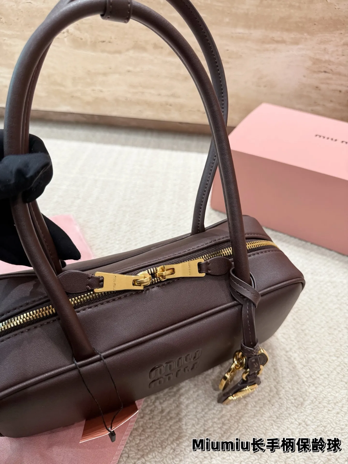 P220 配挂件 size：27.12cm miumiu保龄球长手柄 对版面料 皮质光滑细腻柔软， 棉质缎面衬里。 背起来都很nice 哦 可手拎也可斜挎！ 出场就是miumiu小公主！