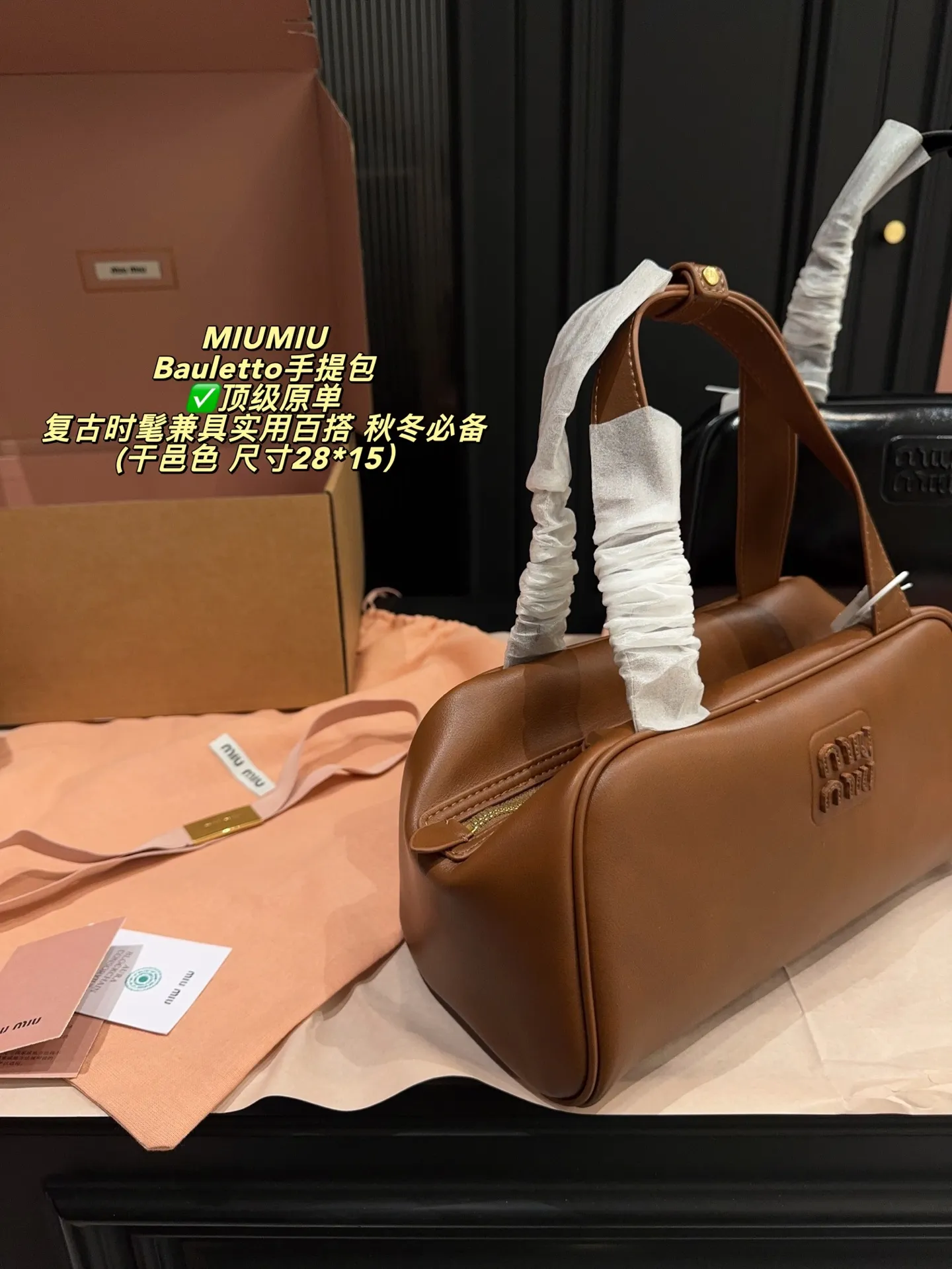 ✅顶级原单P250全套包装⚠️尺寸28*15 MIUMIU 缪缪 Bauletto手提包 选用柔软小牛皮，亮面质感＋细腻粒纹，低调又高级。经典保龄球包造型，扁平手柄设计，手提超舒适！正面低调徽标，细节满分。内部空问大，拉链开口更安全，通勤或出行都很适合二。黑色百搭，秋冬毛衣大衣都能轻松驾驭，是实用又时髦的必备单品！