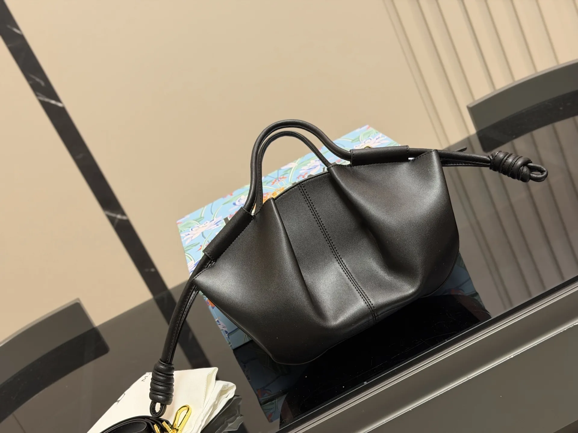 &yen;180 配盒 Loewe罗意威新款Paseo饺子包 做工精致廓形简洁优雅， 带来了柔软和超轻盈的独特复褶构造。 采用闪亮纳帕牛皮革制成。 *手拿或肩背*可拆卸和可调节肩带* 顶部隐形拉链*金色绒面革衬里*烫金。 尺寸:25.18cm