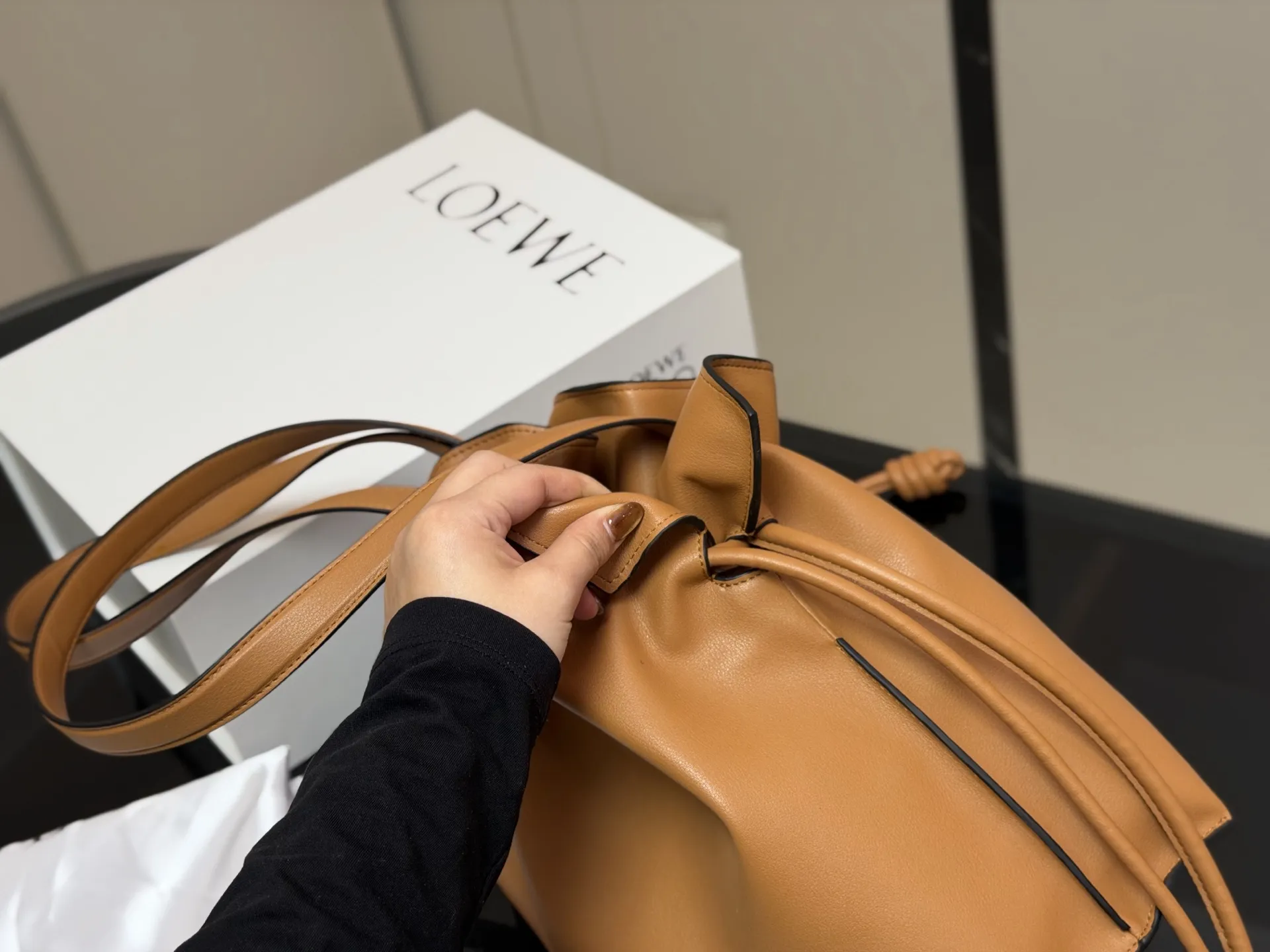 ¥300 配折叠盒 LOEWE 罗意威Anagram福袋托特包 采用柔软纳帕牛皮,手感细腻,廓形随性慵懒。灵感源自日本福袋,抽绳设计方便开合,容量超大,通勤日常都很实用。肩带可调节,支持单肩或斜挎,搭配Anagram印花,低调又有辨识度,时髦精们必入! 尺寸:37.29cm