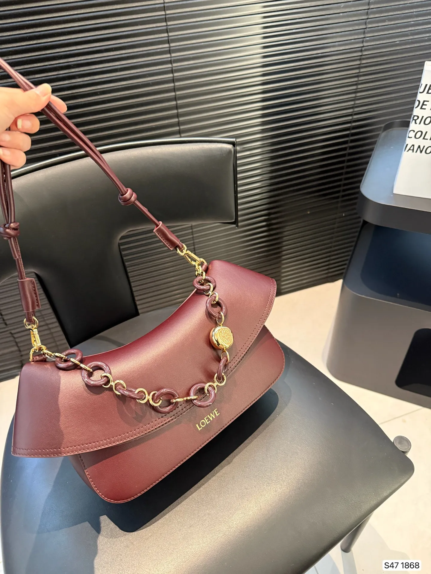 P285 罗意威LOEWE|七夕限定 Ola手袋，一眼心动! LOEWE这款 Ola手袋是七夕专属，简直美哭!弧形设计流畅优雅，搭配醒目的甜甜圈链条，辨识度超高。超实用，光滑牛皮革柔软轻便，背着毫无负担，超适时髦，细节太戳人:可拆卸管状肩带和链条，自由切换单肩或斜挎;翻盖开合顺滑，内袋收纳超方便。LOEWE烫金标志低调奢华，百搭又显气质。 尺寸：26 17 货号1868