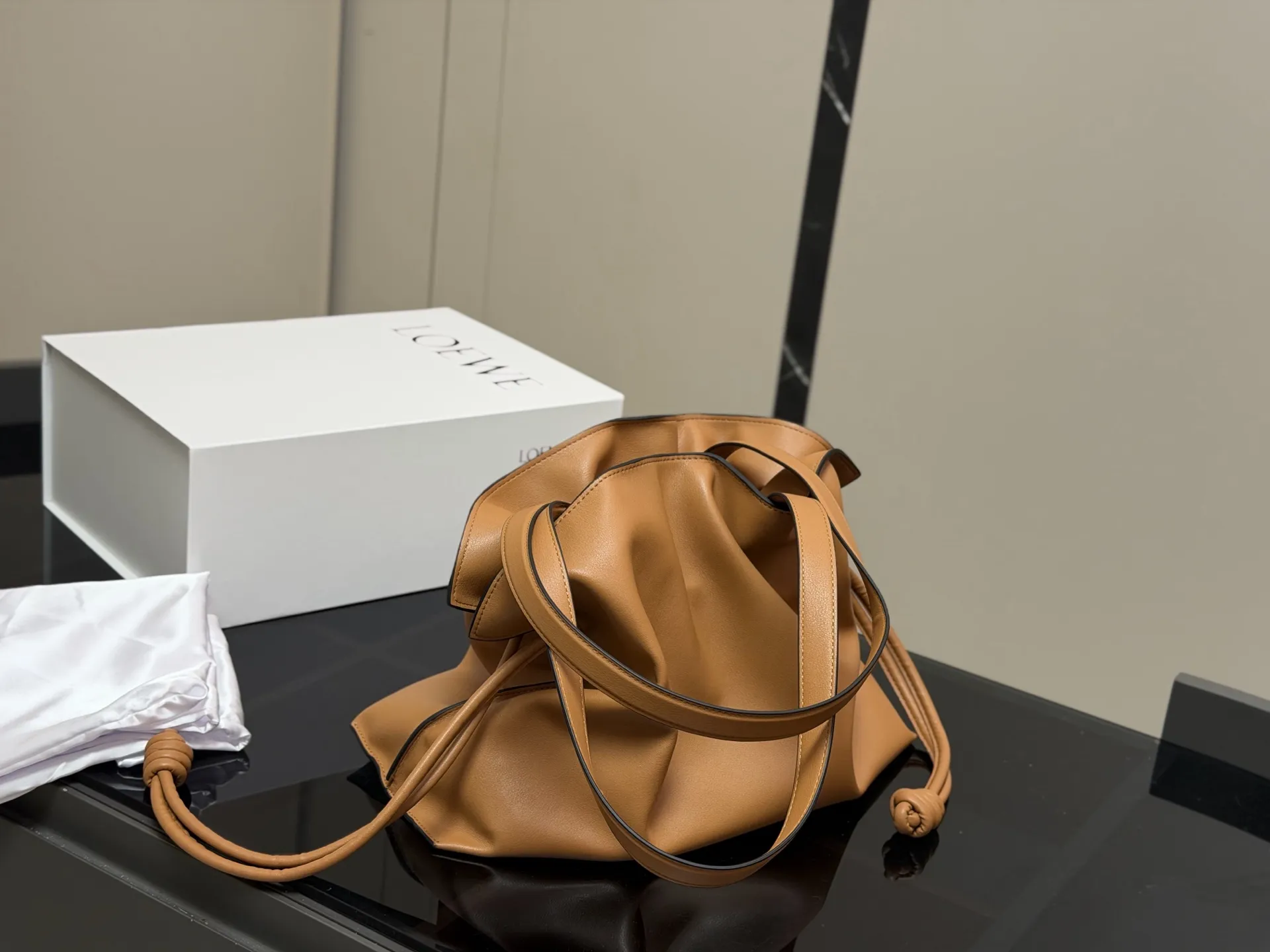 ¥300 配折叠盒 LOEWE 罗意威Anagram福袋托特包 采用柔软纳帕牛皮,手感细腻,廓形随性慵懒。灵感源自日本福袋,抽绳设计方便开合,容量超大,通勤日常都很实用。肩带可调节,支持单肩或斜挎,搭配Anagram印花,低调又有辨识度,时髦精们必入! 尺寸:37.29cm