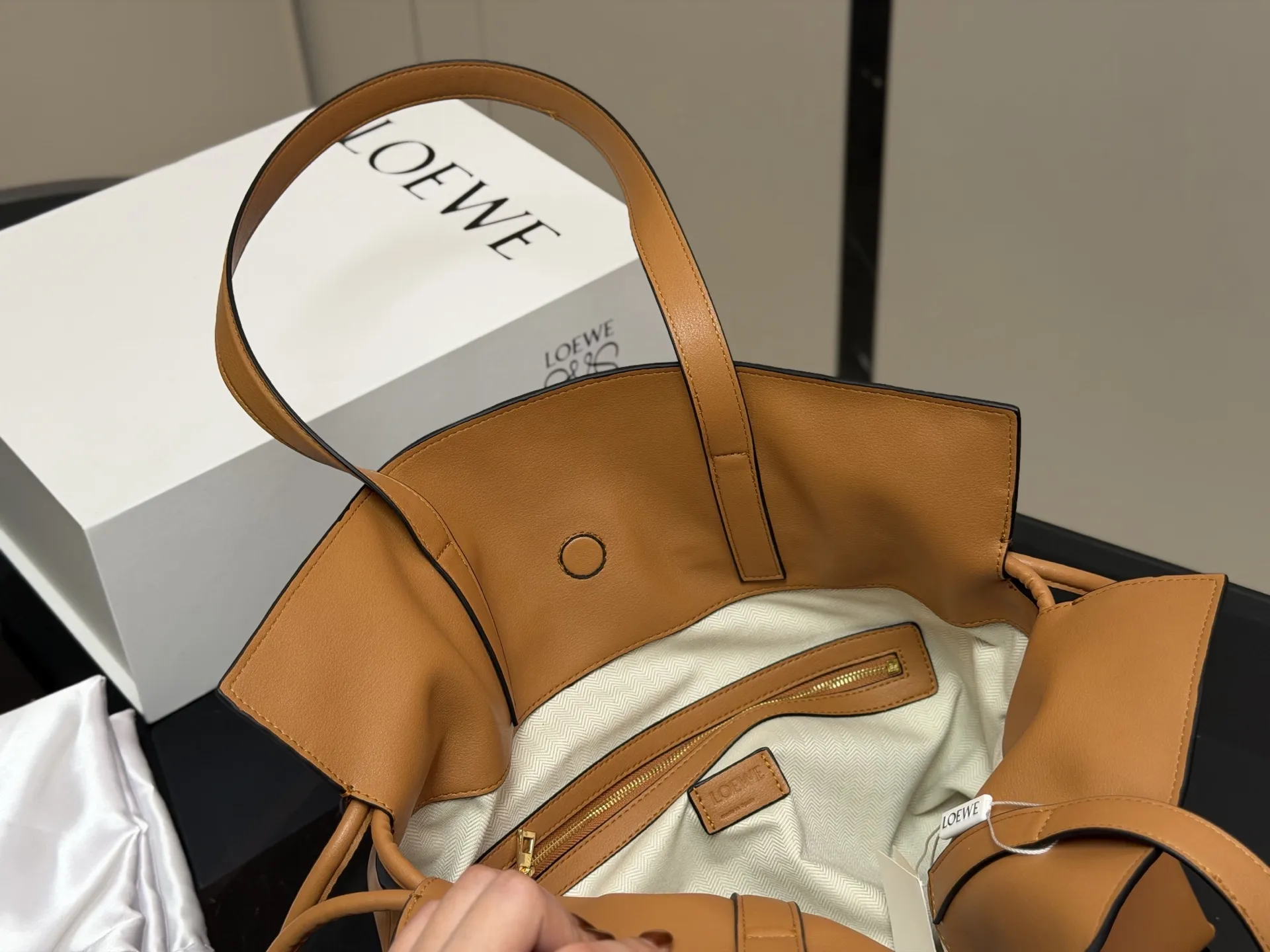 &yen;300 配折叠盒 LOEWE 罗意威Anagram福袋托特包 采用柔软纳帕牛皮，手感细腻，廓形随性慵懒。灵感源自日本福袋，抽绳设计方便开合，容量超大，通勤日常都很实用。肩带可调节，支持单肩或斜挎，搭配Anagram印花，低调又有辨识度，时髦精们必入！ 尺寸:37.29cm