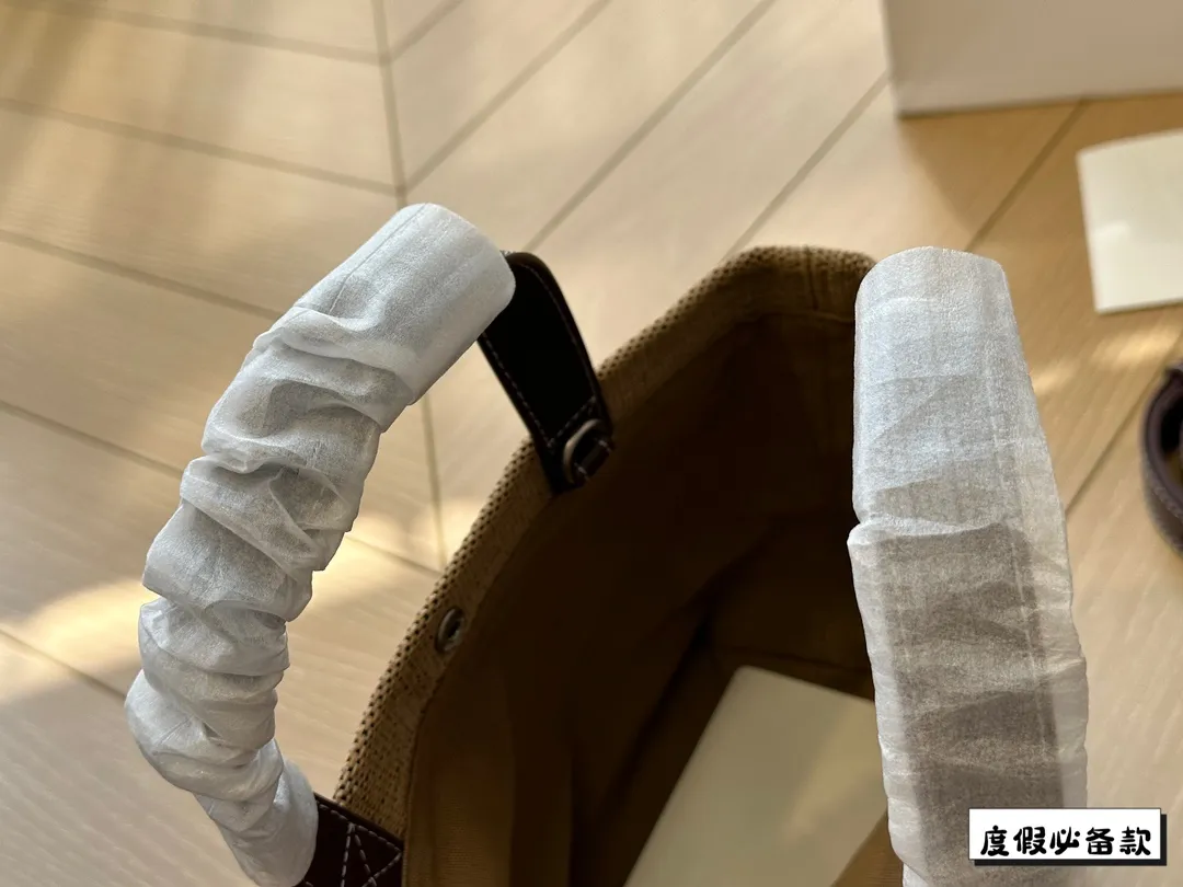 ¥220 Celine新款编织托特包 Celine新款编织包是一款设计简洁而又不失时尚感的托特包。其最显著的特点在于采用了棕色粗细不均条纹的帆布材质,这种设计不仅赋予了包包独特的视觉冲击力,也展现了Celine品牌一贯的优雅与精致。在包的正面醒目地印有大写的“CELINE”字样,既凸显了品牌的身份,也提升了包包的整体美感。20*17