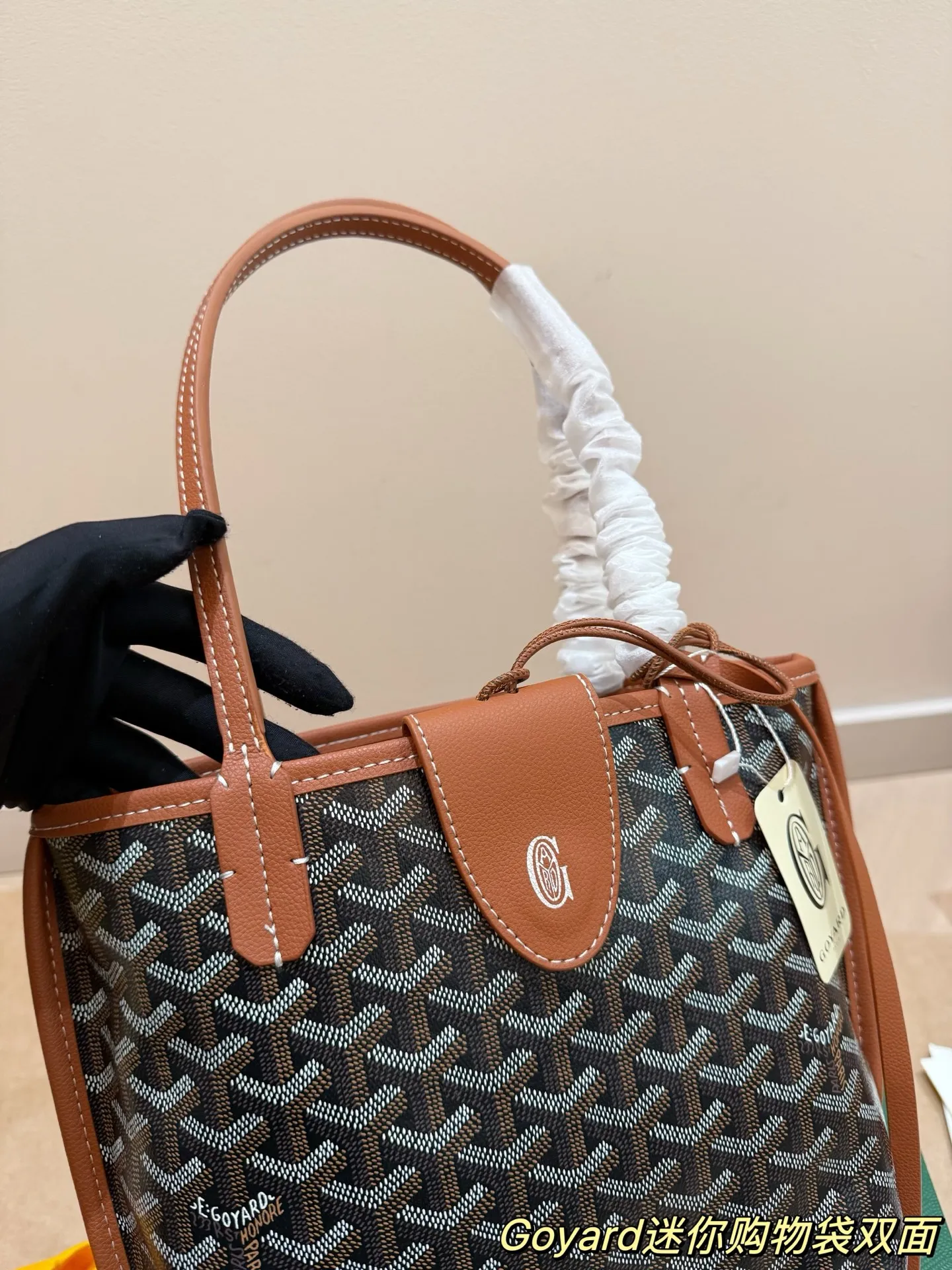 P150 Goyard Goyardine手提包 法国奢侈品牌Goyard的Goyardine手提包,采用经典老花帆布+黑色皮革饰边,简约又超有辨识度t+。独特几何图案,轻便耐用,日常通勤或休闲都很适合!手提+可调节肩带,手提斜挎随心切换,实用又时髦。Goyard以高级定制和精湛工艺闻名,这款包袋收藏价值满满,时尚爱好者必入!20cm配盒子