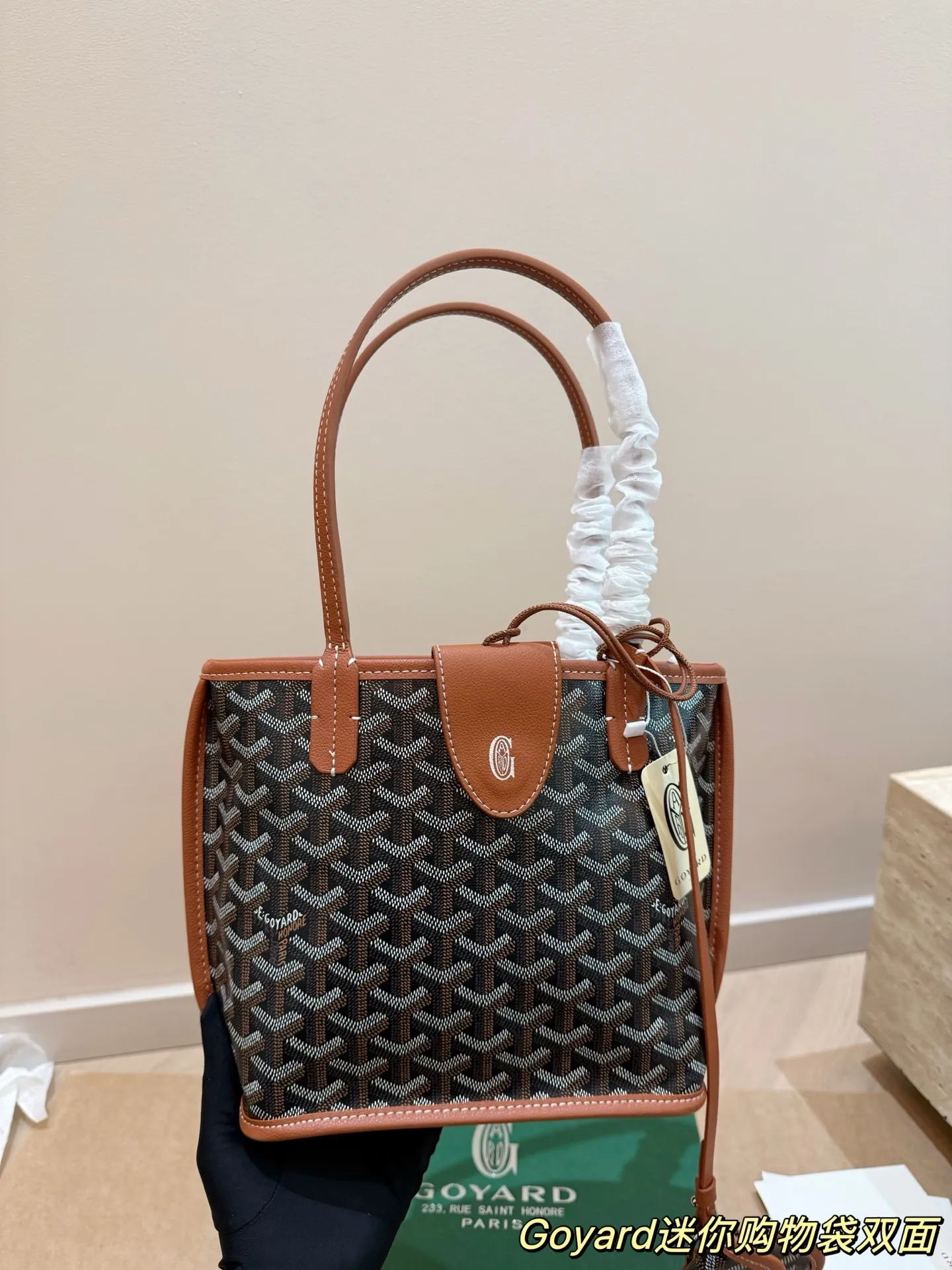 P150 Goyard Goyardine手提包 法国奢侈品牌Goyard的Goyardine手提包,采用经典老花帆布+黑色皮革饰边,简约又超有辨识度t+。独特几何图案,轻便耐用,日常通勤或休闲都很适合!手提+可调节肩带,手提斜挎随心切换,实用又时髦。Goyard以高级定制和精湛工艺闻名,这款包袋收藏价值满满,时尚爱好者必入!20cm配盒子