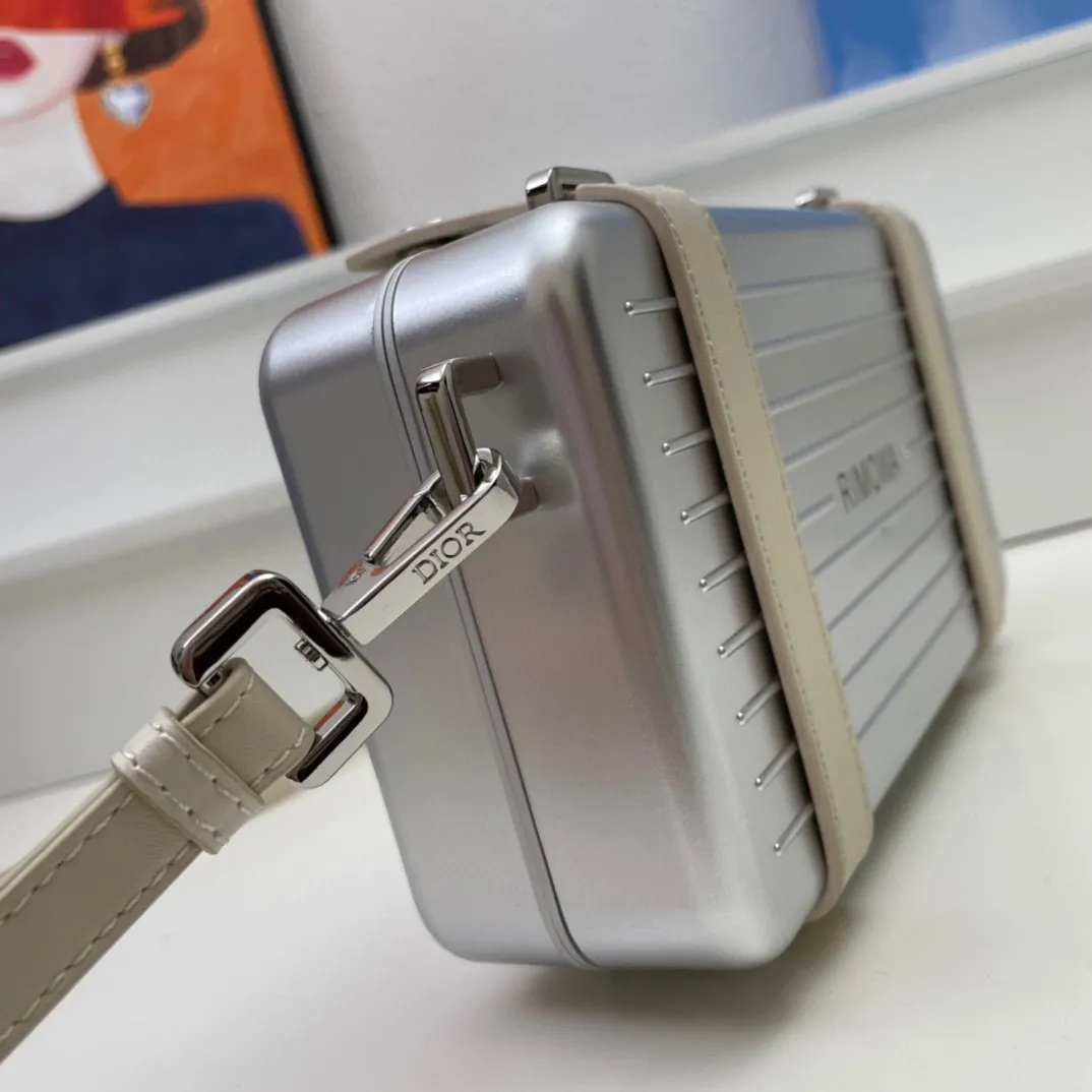 💰230包邮‼️DIOᖇ🎉🎉 (配全套包装) RIMOWA 联名限定款小行李箱子包来啦！自从Rimow&alpha;被巨头收购，感觉档次又提高了一个度，尤其是实物小盒子采用了RIMOWA标志性的磨砂质感的铝制凹槽设计 搭配oblique图案。实物细节设计更高级得没话说，尤其是外壳！有三个隔层，一个拉链零钱袋，还有6个卡位，可以放大手机，看起来不大容量却很足呀，斜挎和手拿都很OK～ 联名款的包设计风格很独特，男生背超级带感，女生背也很帅！ A926# 13.5x20x6.5cm