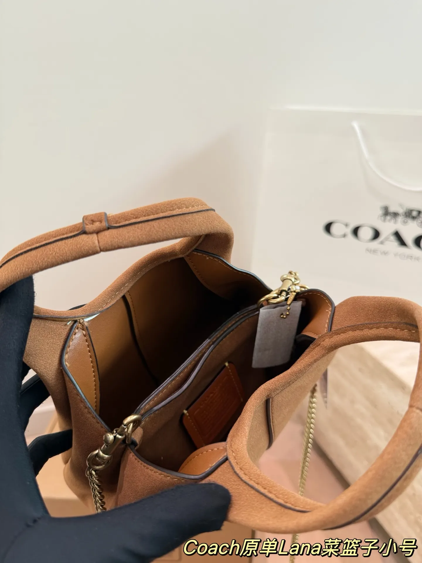 P180 P165 COACH LANA 23号单肩包​​ 👜COACH LANA 23号单肩包，荔枝纹头层牛皮，手感柔软耐用，浅灰调超百搭，通勤休闲都能轻松驾驭✨。小巧尺寸，手提斜挎随心切换，内部隔层方便收纳手机、钥匙、口红等日常小物。金色C字Logo点缀，低调又有辨识度，简约优雅风格，秋冬大衣、针织衫都能轻松搭配，实用又时髦！ 尺寸23cm16cm