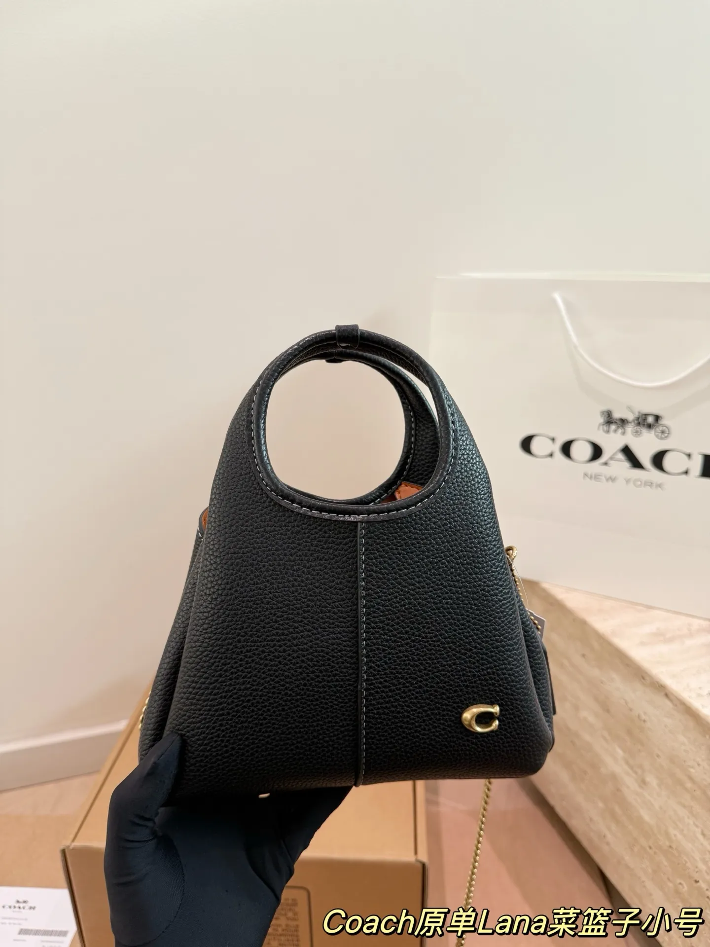 P165 COACH LANA 23号单肩包​​ 👜COACH LANA 23号单肩包，荔枝纹头层牛皮，手感柔软耐用，浅灰调超百搭，通勤休闲都能轻松驾驭✨。小巧尺寸，手提斜挎随心切换，内部隔层方便收纳手机、钥匙、口红等日常小物。金色C字Logo点缀，低调又有辨识度，简约优雅风格，秋冬大衣、针织衫都能轻松搭配，实用又时髦！ 尺寸16cm