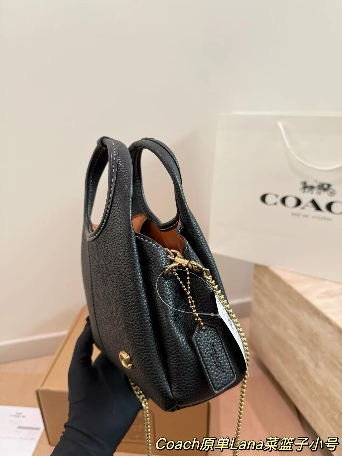 P165 COACH LANA 23号单肩包​​ 👜COACH LANA 23号单肩包，荔枝纹头层牛皮，手感柔软耐用，浅灰调超百搭，通勤休闲都能轻松驾驭✨。小巧尺寸，手提斜挎随心切换，内部隔层方便收纳手机、钥匙、口红等日常小物。金色C字Logo点缀，低调又有辨识度，简约优雅风格，秋冬大衣、针织衫都能轻松搭配，实用又时髦！ 尺寸16cm