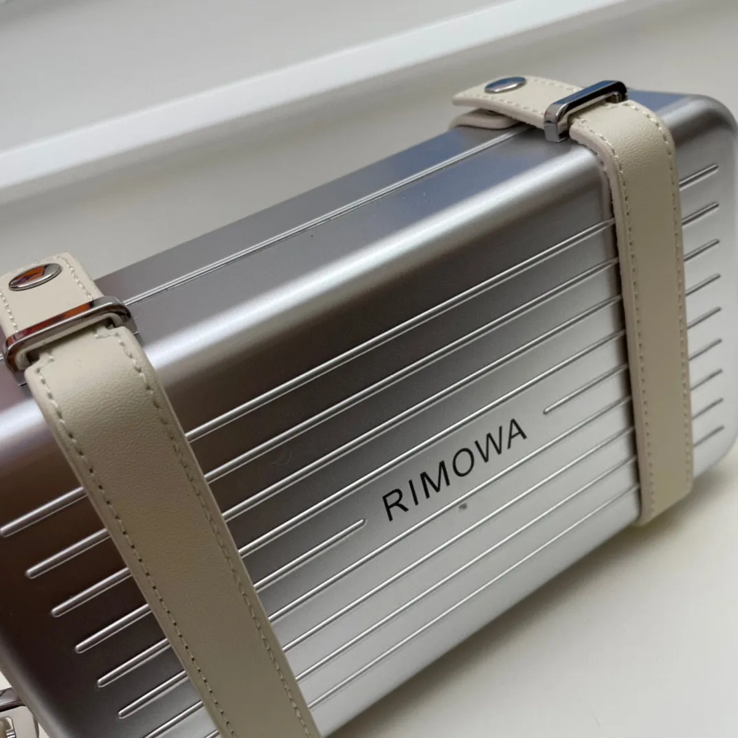 💰230包邮‼️DIOᖇ🎉🎉 (配全套包装) RIMOWA 联名限定款小行李箱子包来啦!自从Rimowα被巨头收购,感觉档次又提高了一个度,尤其是实物小盒子采用了RIMOWA标志性的磨砂质感的铝制凹槽设计 搭配oblique图案。实物细节设计更高级得没话说,尤其是外壳!有三个隔层,一个拉链零钱袋,还有6个卡位,可以放大手机,看起来不大容量却很足呀,斜挎和手拿都很OK~ 联名款的包设计风格很独特,男生背超级带感,女生背也很帅! A926# 13.5x20x6.5cm