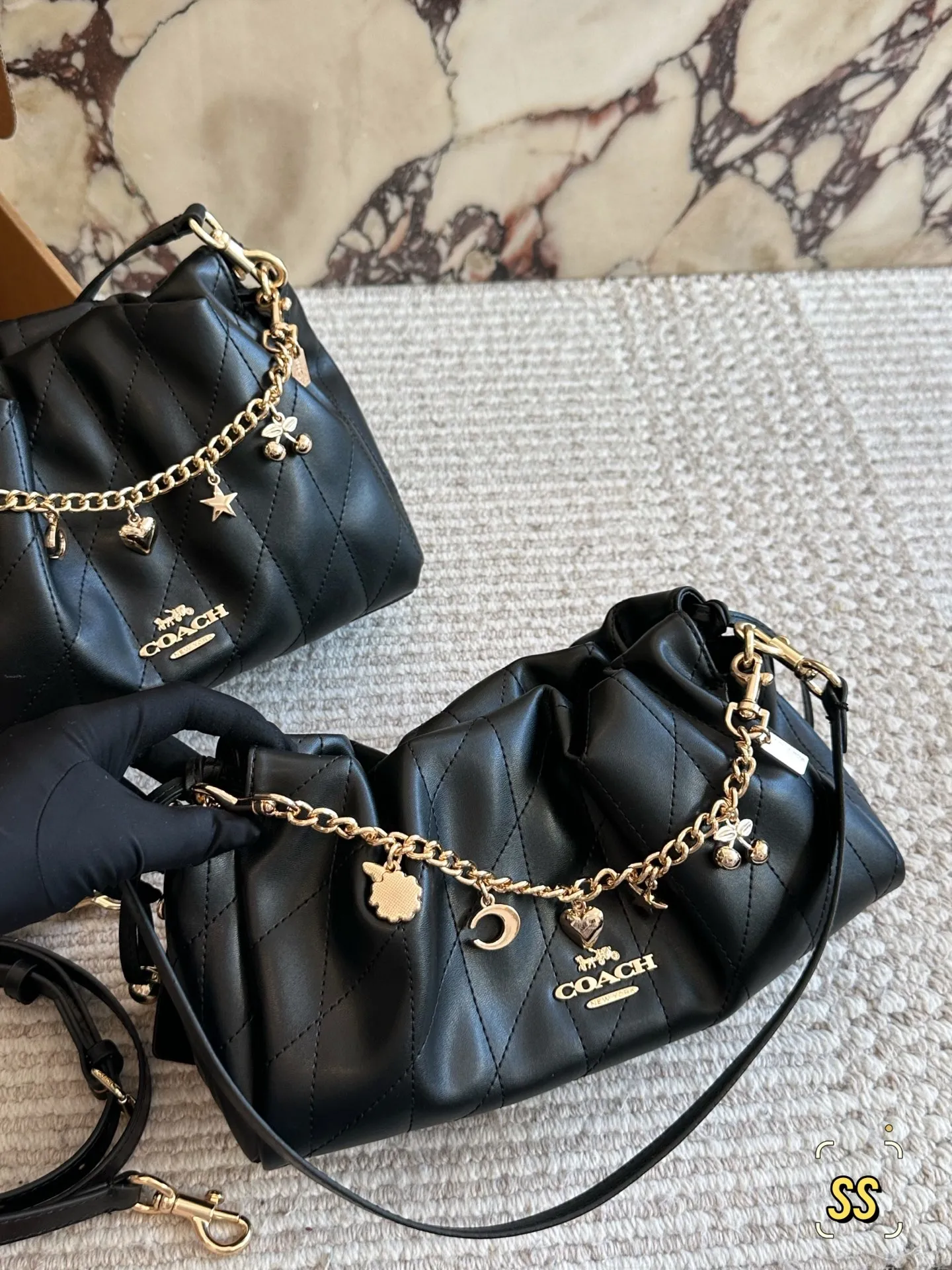 横版💰155、竖版💰160 圣诞礼物🎁云朵包软糯羊皮绗缝太戳心💘 姐妹们!Coach这次的新款Faye云朵包真的绝了!一上手就忍不住来分享✨ 迷你尺寸也太可爱了吧!比想象中能装多了~手机口红粉饼通通塞进去还有空间,日常出街完全够用。最惊艳的是全羊皮材质,摸起来像云朵一样软fufu的~手感绝绝子! 高级感满满的绗缝工艺让整个包立体感up⬆️,光线下一照还有细腻的光泽。链条可以调节长短,单肩斜挎都好看,冬天配大衣简直气质爆棚! 奶油白温柔到不行,同款还有黑色/焦糖色也超百搭。重点是不会像小羊皮那么娇气,耐磨度意外能打!横版23*18/竖版28*16