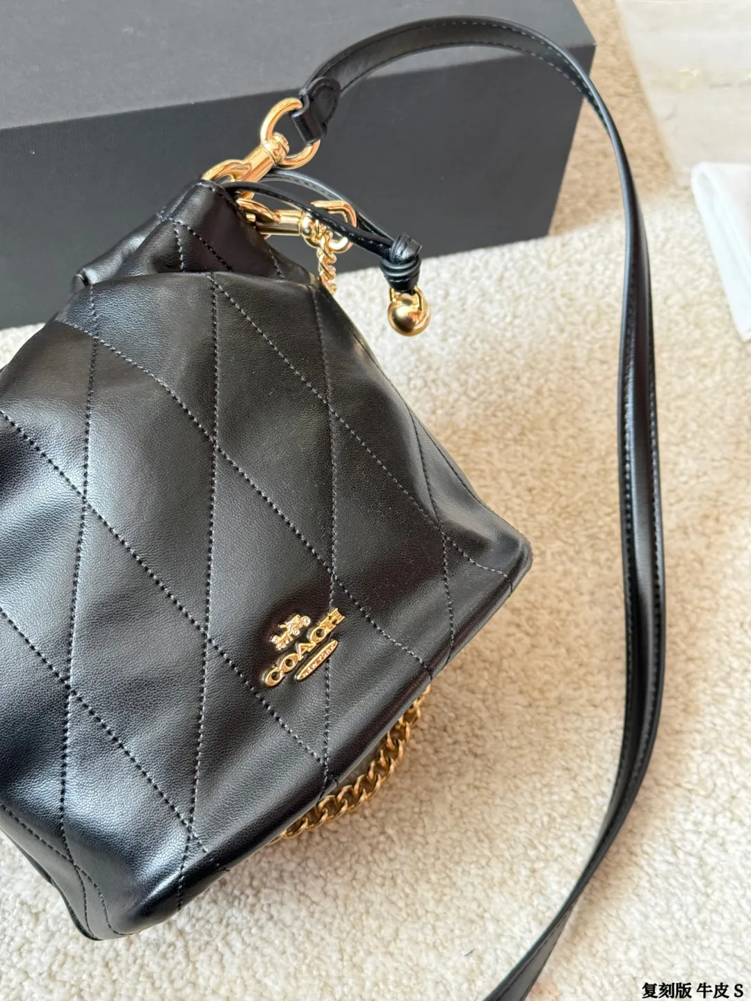 复刻版牛皮 p195 Coach Faye迷你抽绳水桶包 Coach Faye迷你抽绳水桶包，奶白色全皮+金属链条，简约优雅又百搭！抽绳设计超灵活，链条可调节，手提、单肩、斜挎都OK，通勤休闲都能驾驭。包身小巧但容量实用，手机、口红、钥匙轻松收纳。柔软皮质+褶皱细节，质感满分，秋冬搭配裙子或牛仔裤都很出彩，温柔又俏皮，是穿搭点睛之选 尺寸 18 15cm