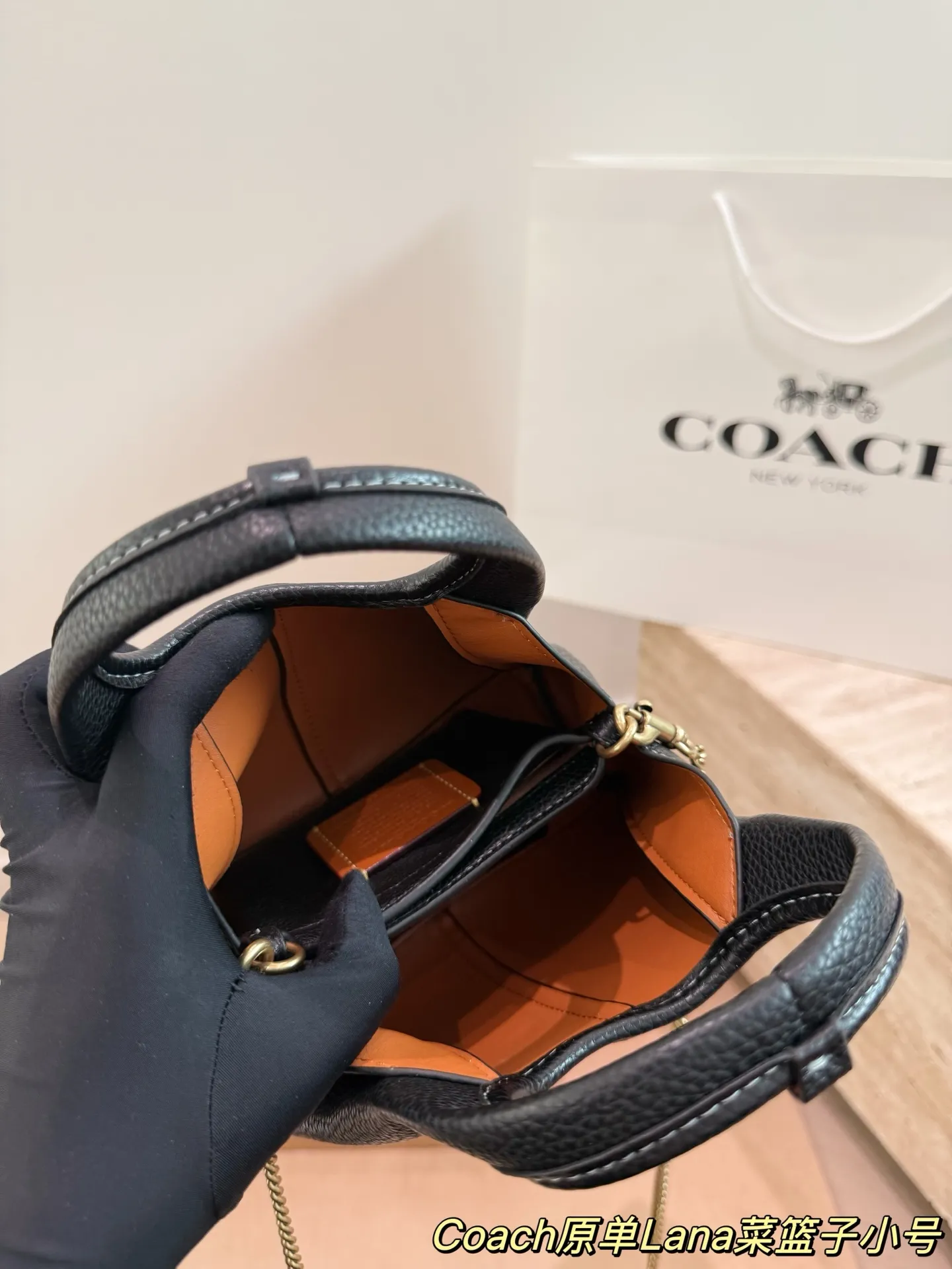 P165 COACH LANA 23号单肩包​​ 👜COACH LANA 23号单肩包，荔枝纹头层牛皮，手感柔软耐用，浅灰调超百搭，通勤休闲都能轻松驾驭✨。小巧尺寸，手提斜挎随心切换，内部隔层方便收纳手机、钥匙、口红等日常小物。金色C字Logo点缀，低调又有辨识度，简约优雅风格，秋冬大衣、针织衫都能轻松搭配，实用又时髦！ 尺寸16cm