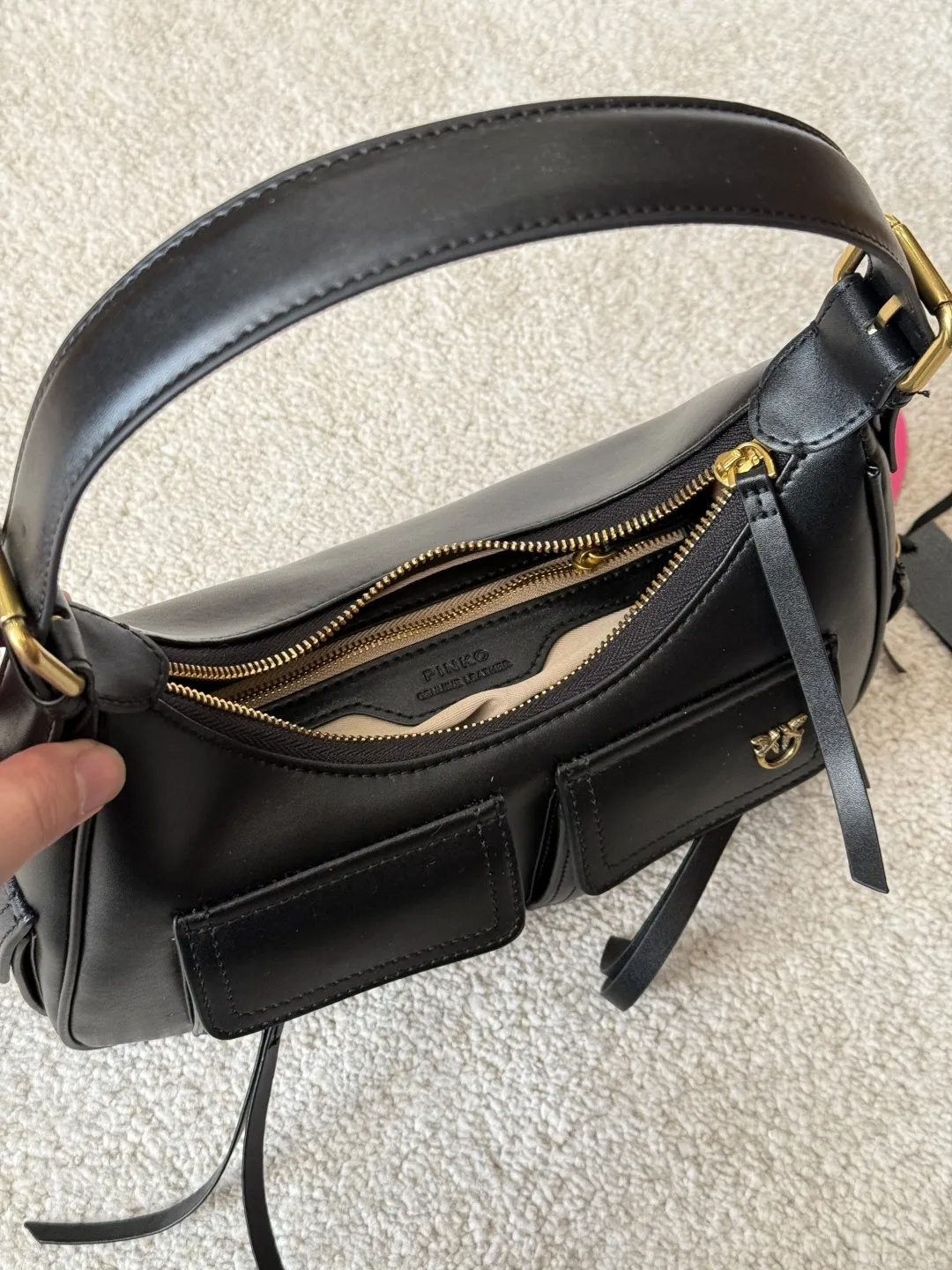 复刻版 p205 PINKO 燕子 多口袋机车包 PINKO这款多口袋机车包,黑色皮革+金色五金,简约又有细节感。正面双拉链口袋,收纳方便,中央飞鸟 Logo超有辨识度!弧形包身+顶部提手,肩带可调节,手提斜挎都OK~尺寸适中,通勤休闲都能用,实用又时髦,机车风女孩必入! 尺寸 28 18cm