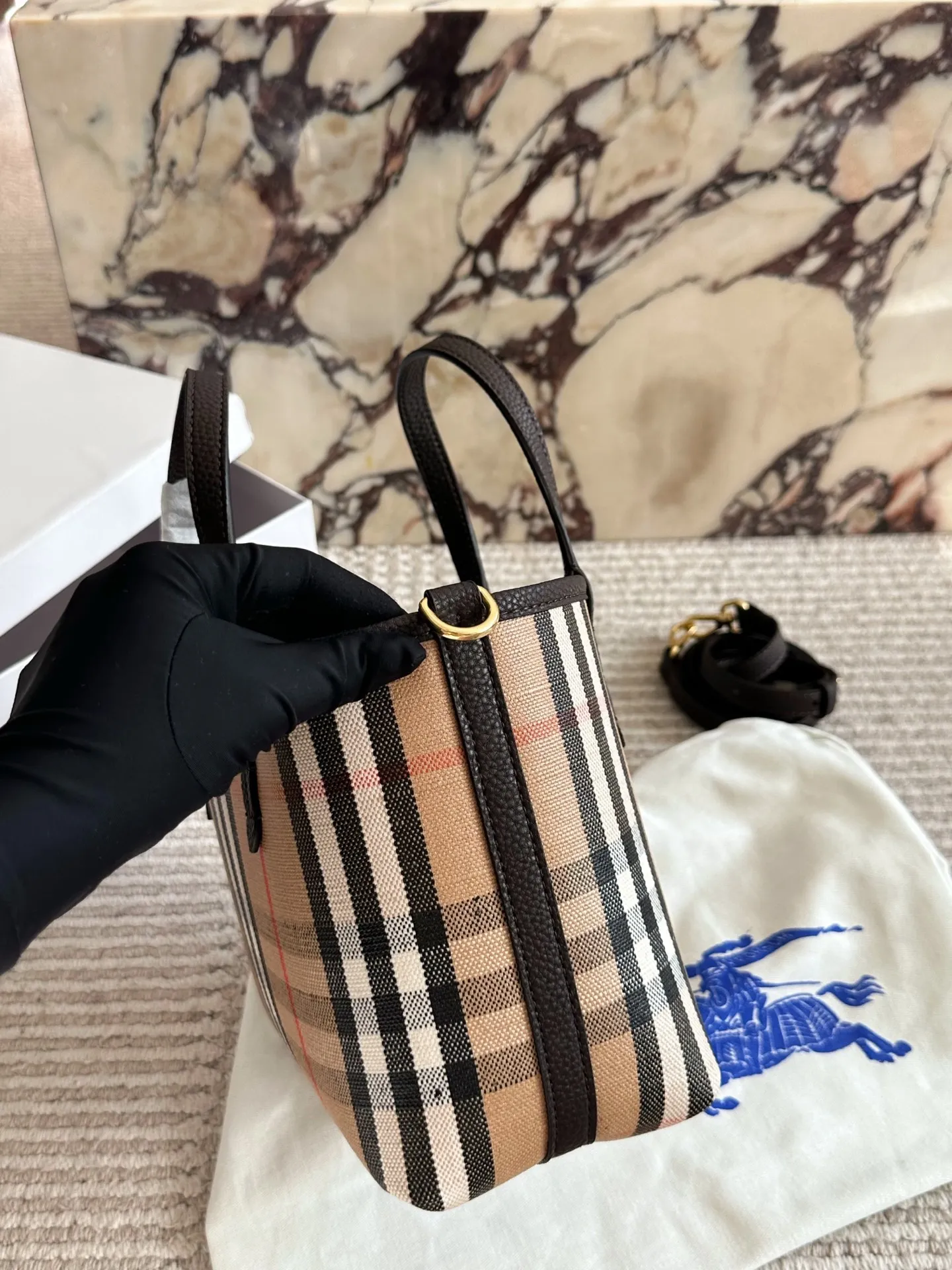 p190 双面tote Burberry家最新格纹迷你托特包,选用棉质帆布面料打造,格子面料搭配光滑皮革顶部提柄,有可调式斜背带。 顶部皮革提柄 可调式网纹肩背带开放式包口设计,搭配磁扣开合内侧口袋采用磁扣开合 尺寸 22 18cm 配盒