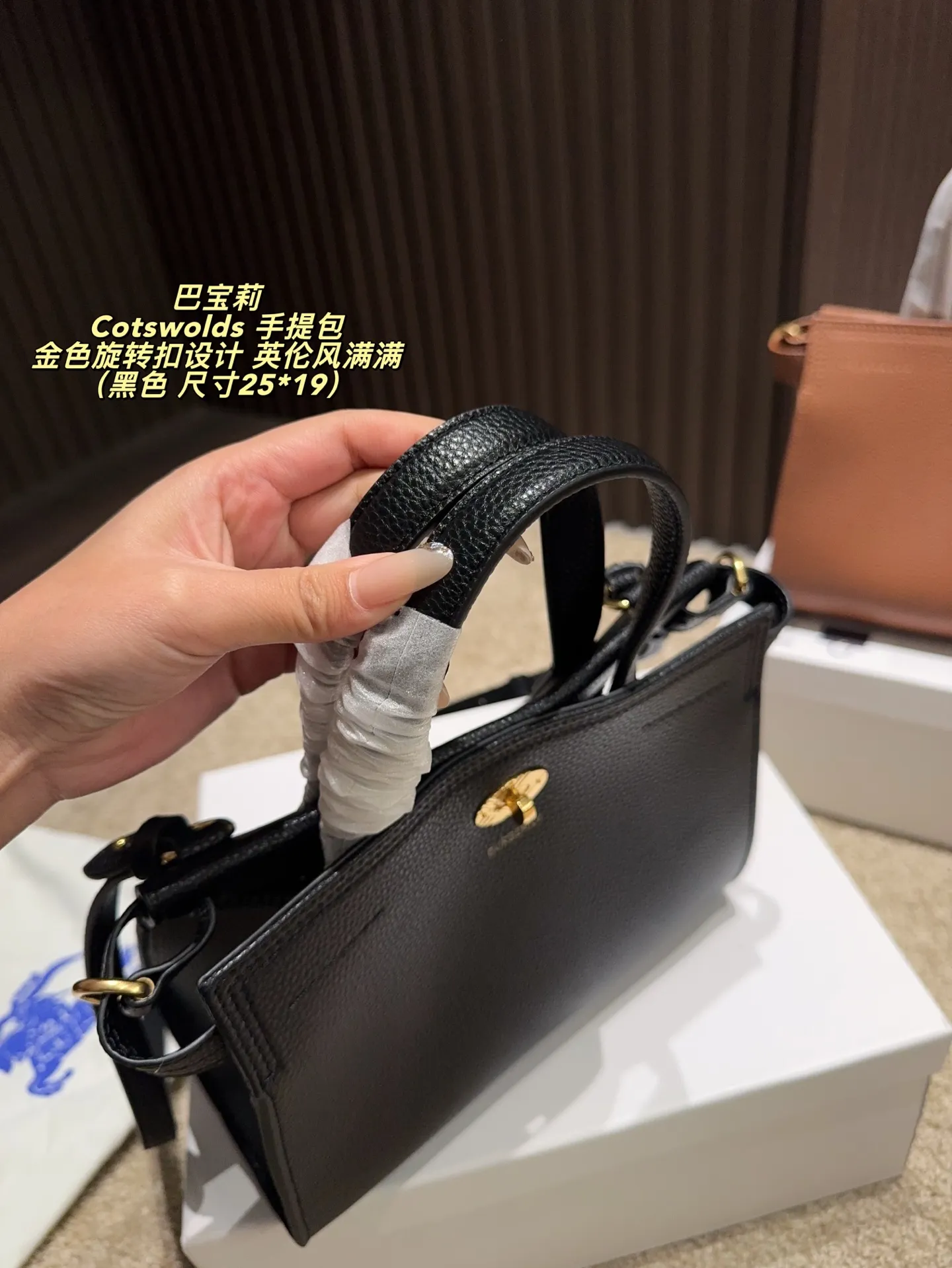 P220配盒⚠️尺寸25*19 Burberry 巴宝莉Cotswolds 手提包 采用粒面小牛皮,质感细腻耐用,低调奢华。金色旋转扣设计,英伦风满满,简约又精致。包身轻盈,容量适中,通勤或出行都很实用。内部空问合理,日常物品轻松收纳。黑色款百搭,适合多种穿搭,是实用与时尚兼具的经典之选的。