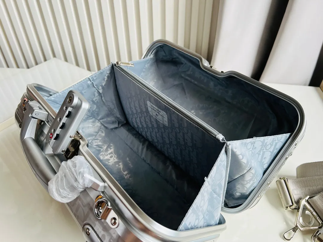 Dior联名日默瓦rimowa手提箱14寸随身登机 38cm 本季推出的 Dior & Rimowa@38 厘米手提化妆箱,可可单肩/可斜挎;选用 Damier Graphite 帆布内里,印有男装艺术总监 Virgil Abloh 设计的新款彩色交织dr系列的字母。光滑外层包裹轻巧的铝制手提和高密度斜挎带,使整个手提箱高级感倍增。箱内设计精简,左右带两居室的内测,实用且不失奢华,内里还包括 1 个拉链隔层和 1 个小插袋。 详细特征 38.0 x 16.5.0 x 22.0 cm (长 x 高 x 宽) ·随身上机行李尺寸 . 单肩/斜挎 .Damier Graphite涂层定制帆布 .两居室内衬 .牛皮饰边 .铝制饰件 . .箱内人性化合理设计 .dr家专属内里隔层 .顶部配有合金手柄 .镁铝合金包角 .内里拉链开合,配有tsa海关锁 .4个小巧防滑底座