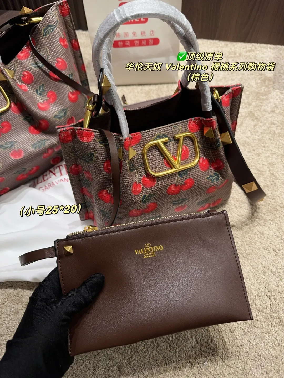 ✅顶级原单 大号p220配盒⚠️尺寸37.23 小号p205配盒⚠️尺寸25.20 华伦天奴 Valentino 樱桃系列购物袋 上面鲜艳欲滴的樱桃搭配墨绿枝叶,复古田园风扑面而来,仿佛一秒穿越到浪漫田园🍃 棕色皮革包边精致得不行,标志性的金属“V”扣更是吸睛利器,质感瞬间拉满,高级感爆棚✨这包包超百搭,搭小裙子,甜美气质尽显;配休闲装,又能展现酷帅一面,分分钟点亮整体造型。背它出门,你就是人见人爱的甜酷女孩
