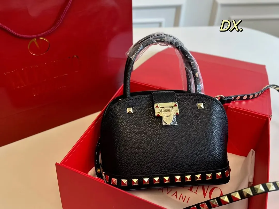 P180（折叠盒） size：21&times;16 VALENTINO 华伦天奴铆钉贝壳包❤️ 经典贝壳包型配有铆钉点缀✔️好 时尚的同时兼具实用手提功能！ 底部铆钉装饰太高级了 细节感满🈵️ 稳重又不失酷帅风格✅