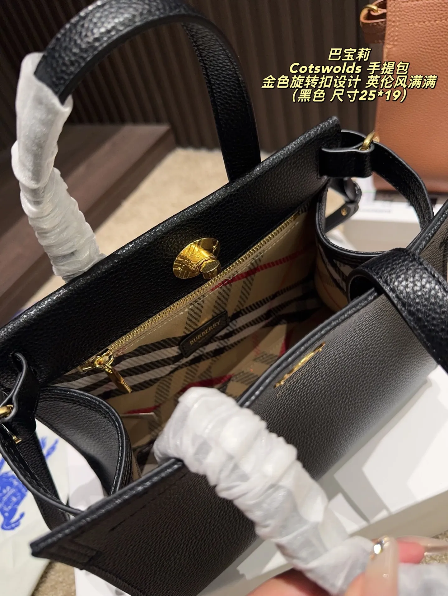 P220配盒⚠️尺寸25*19 Burberry 巴宝莉Cotswolds 手提包 采用粒面小牛皮,质感细腻耐用,低调奢华。金色旋转扣设计,英伦风满满,简约又精致。包身轻盈,容量适中,通勤或出行都很实用。内部空问合理,日常物品轻松收纳。黑色款百搭,适合多种穿搭,是实用与时尚兼具的经典之选的。