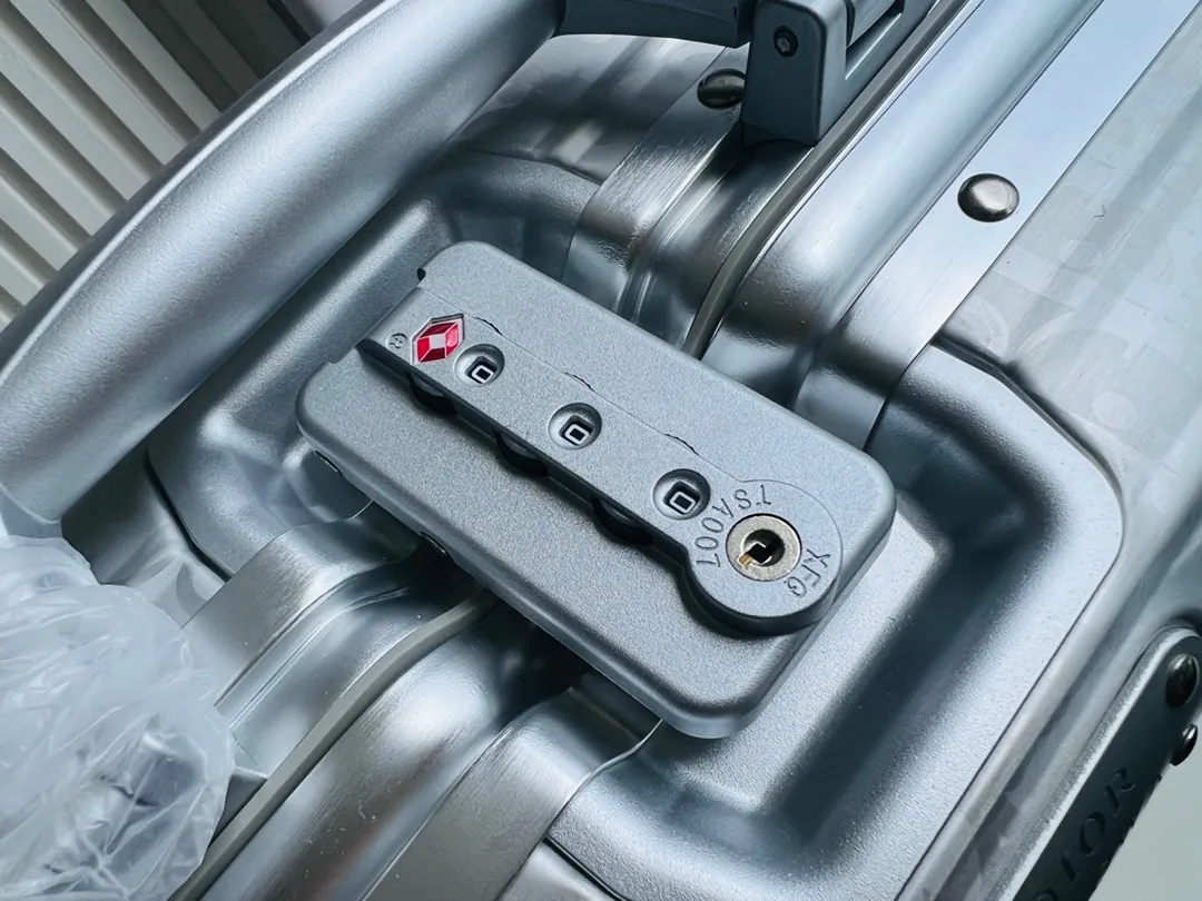 Dior联名日默瓦rimowa手提箱14寸随身登机 38cm 本季推出的 Dior & Rimowa@38 厘米手提化妆箱，可可单肩/可斜挎；选用 Damier Graphite 帆布内里，印有男装艺术总监 Virgil Abloh 设计的新款彩色交织dr系列的字母。光滑外层包裹轻巧的铝制手提和高密度斜挎带，使整个手提箱高级感倍增。箱内设计精简，左右带两居室的内测，实用且不失奢华，内里还包括 1 个拉链隔层和 1 个小插袋。 详细特征 38.0 x 16.5.0 x 22.0 cm (长 x 高 x 宽) &middot;随身上机行李尺寸 . 单肩/斜挎 ．Damier Graphite涂层定制帆布 ．两居室内衬 ．牛皮饰边 ．铝制饰件 ． ．箱内人性化合理设计 ．dr家专属内里隔层 ．顶部配有合金手柄 ．镁铝合金包角 ．内里拉链开合，配有tsa海关锁 ．4个小巧防滑底座