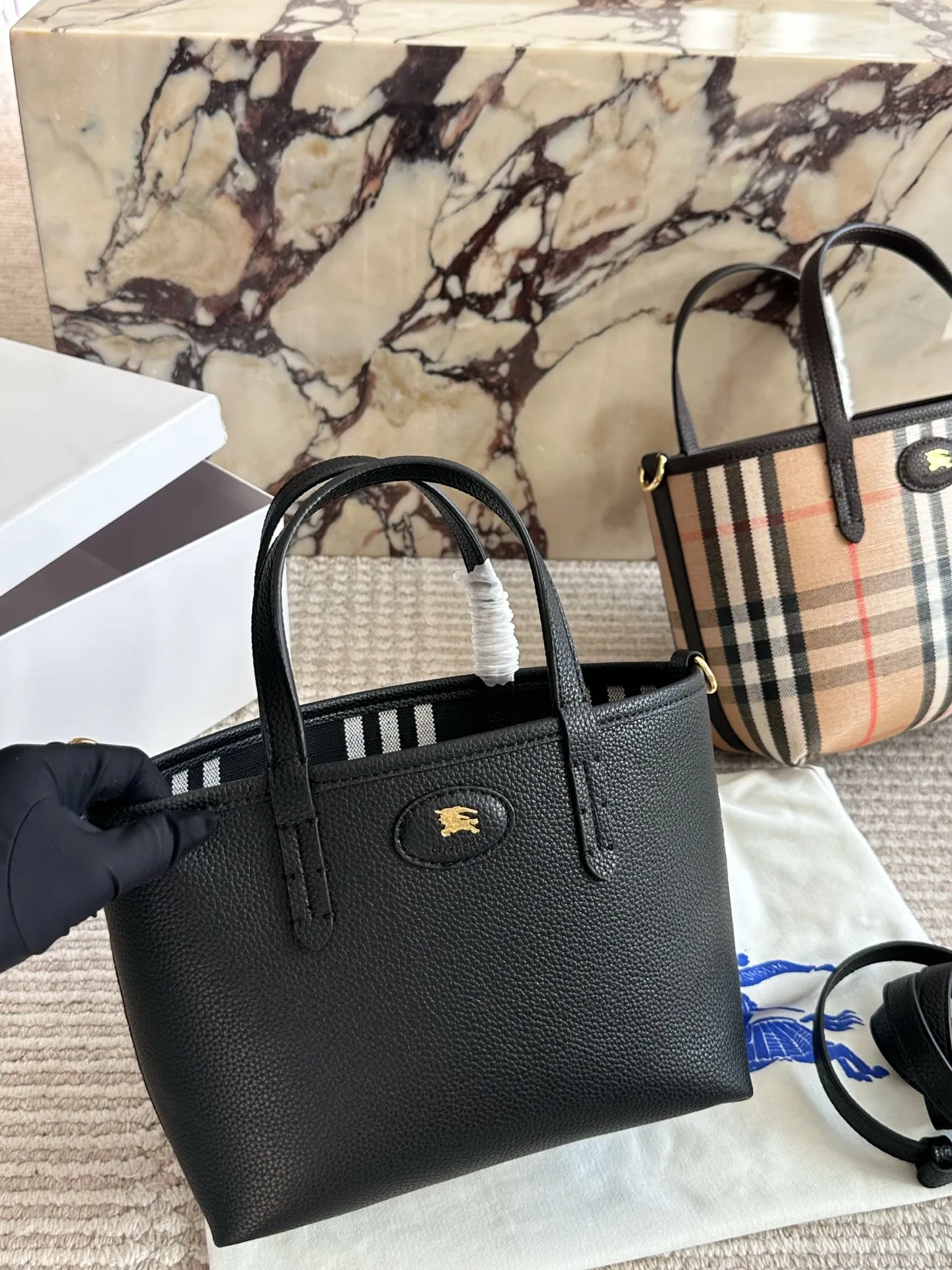 p190 双面tote Burberry家最新格纹迷你托特包,选用棉质帆布面料打造,格子面料搭配光滑皮革顶部提柄,有可调式斜背带。 顶部皮革提柄 可调式网纹肩背带开放式包口设计,搭配磁扣开合内侧口袋采用磁扣开合 尺寸 22 18cm 配盒