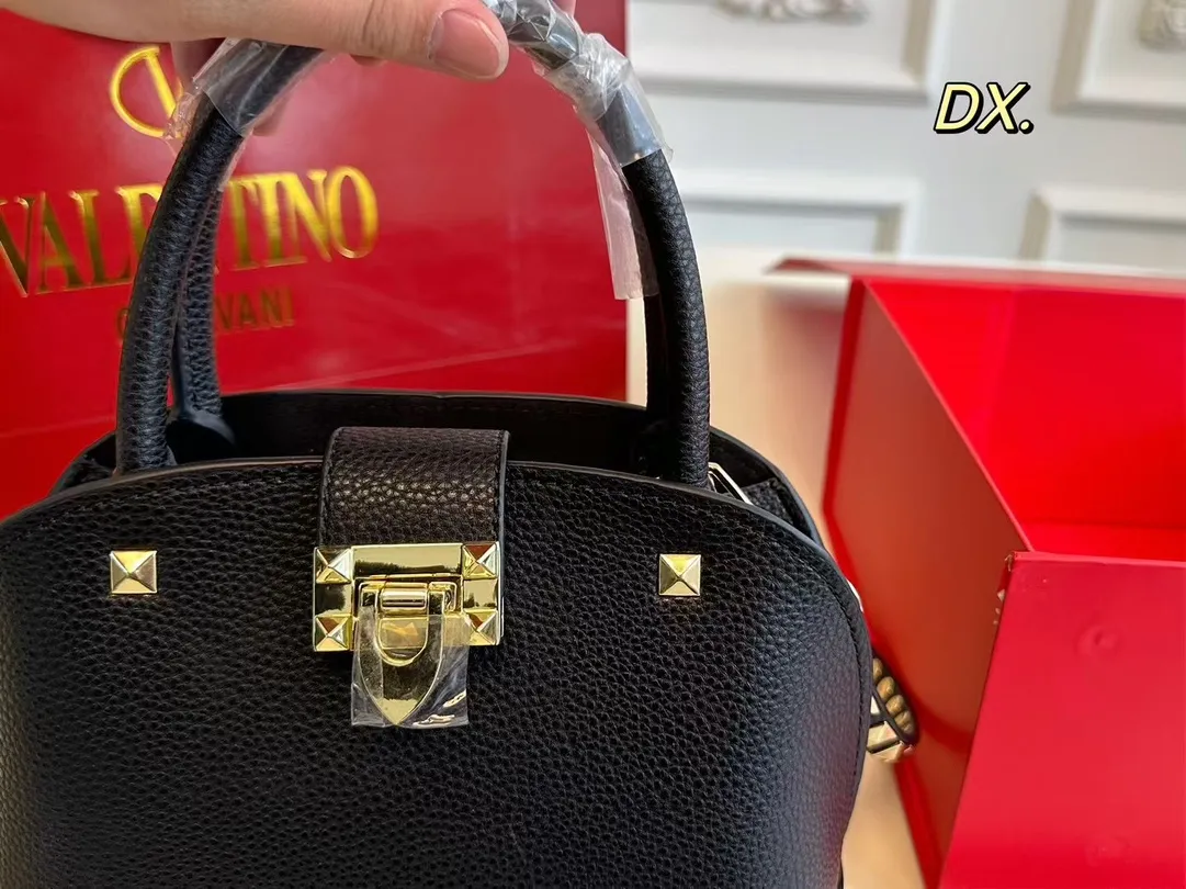 P180（折叠盒） size：21&times;16 VALENTINO 华伦天奴铆钉贝壳包❤️ 经典贝壳包型配有铆钉点缀✔️好 时尚的同时兼具实用手提功能！ 底部铆钉装饰太高级了 细节感满🈵️ 稳重又不失酷帅风格✅