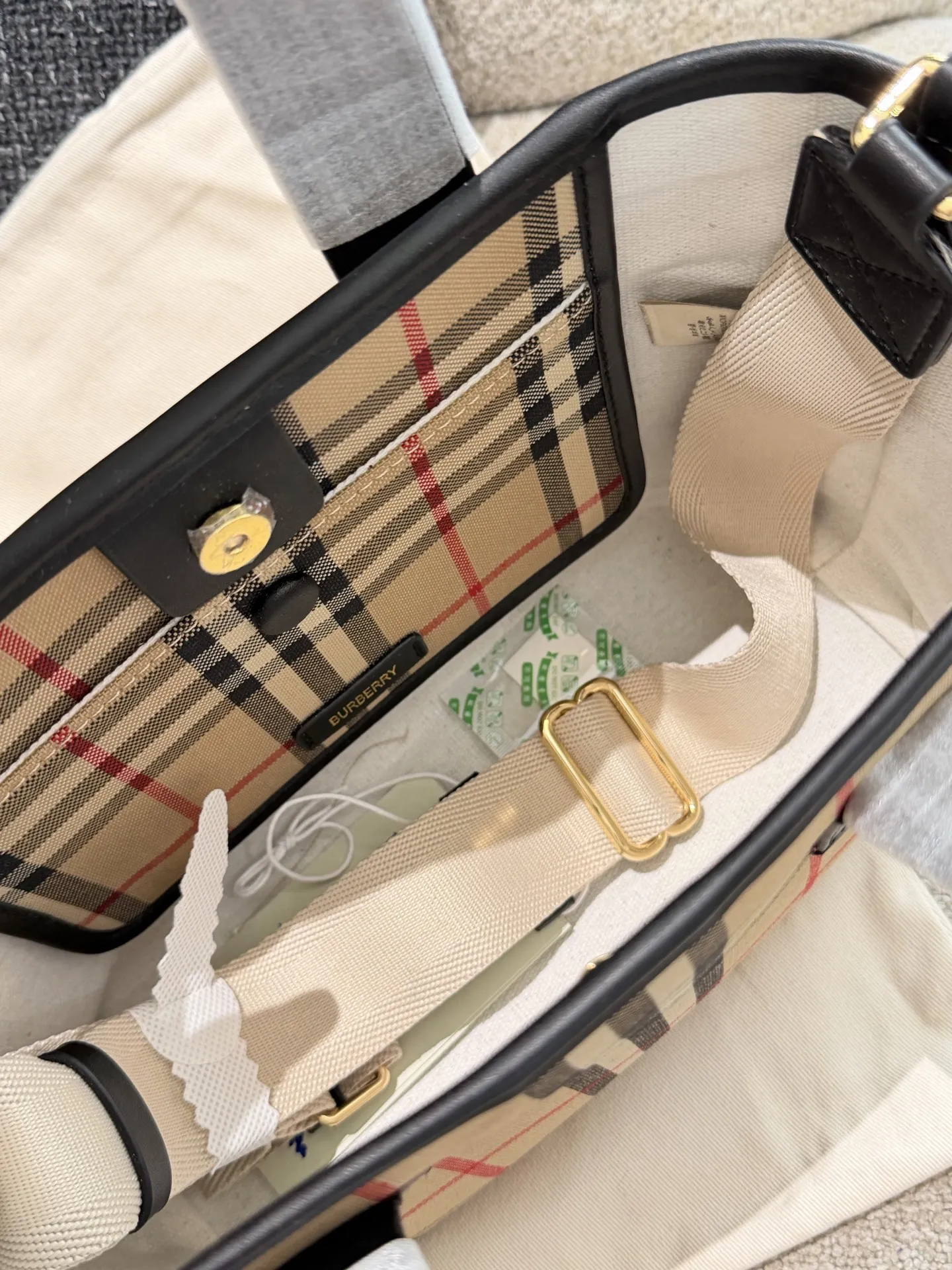 p150 Burberry家最新格纹迷你托特包，选用棉质帆布面料打造，格子面料搭配光滑皮革顶部提柄，有可调式斜背带。 顶部皮革提柄 可调式网纹肩背带开放式包口设计，搭配磁扣开合内侧口袋采用磁扣开合 尺寸 27/16.5/10