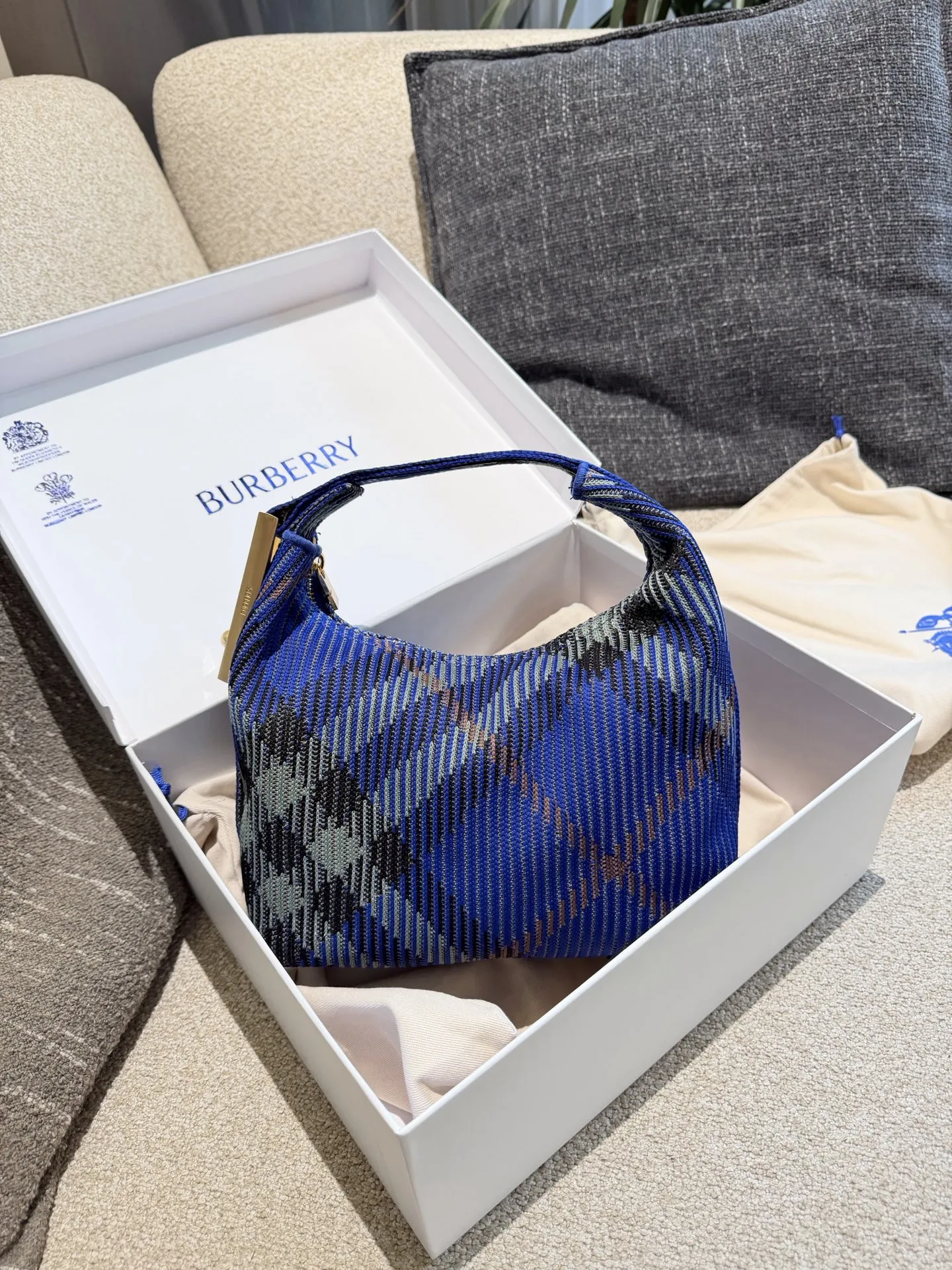 p215 Burberry粉色Peg腋下包 Burberry粉色Peg腋下包，采用柔软编织材质,触感温暖轻盈，春夏穿搭超适合!包身简约，经典格纹+蜜桃粉，清新优雅又百搭+。23x10.5x21.5cm约23x10.5x21.5cm，容量适中，通勤休闲都能hold住。双提手设计，手提肩背都OK，实用又时髦。Peg系列是Burberry经典款，时尚圈超受欢迎，春夏裙装或休闲装都能轻松搭配，日常出街必备!