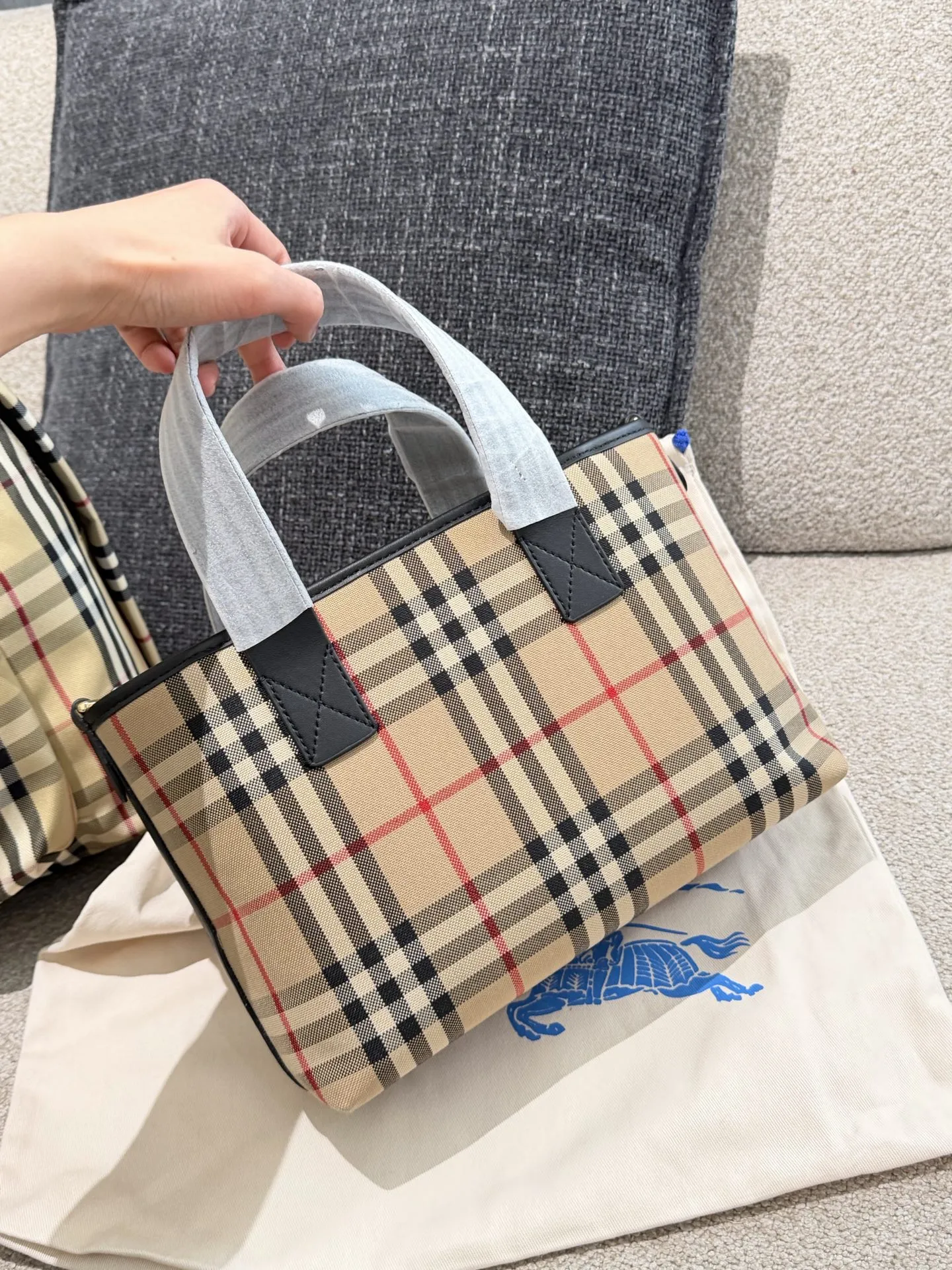 p150 Burberry家最新格纹迷你托特包，选用棉质帆布面料打造，格子面料搭配光滑皮革顶部提柄，有可调式斜背带。 顶部皮革提柄 可调式网纹肩背带开放式包口设计，搭配磁扣开合内侧口袋采用磁扣开合 尺寸 27/16.5/10