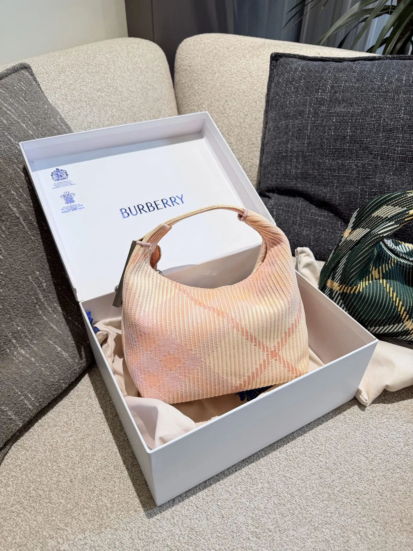 p215 Burberry粉色Peg腋下包 Burberry粉色Peg腋下包,采用柔软编织材质,触感温暖轻盈,春夏穿搭超适合!包身简约,经典格纹+蜜桃粉,清新优雅又百搭+。23x10.5x21.5cm约23x10.5x21.5cm,容量适中,通勤休闲都能hold住。双提手设计,手提肩背都OK,实用又时髦。Peg系列是Burberry经典款,时尚圈超受欢迎,春夏裙装或休闲装都能轻松搭配,日常出街必备!